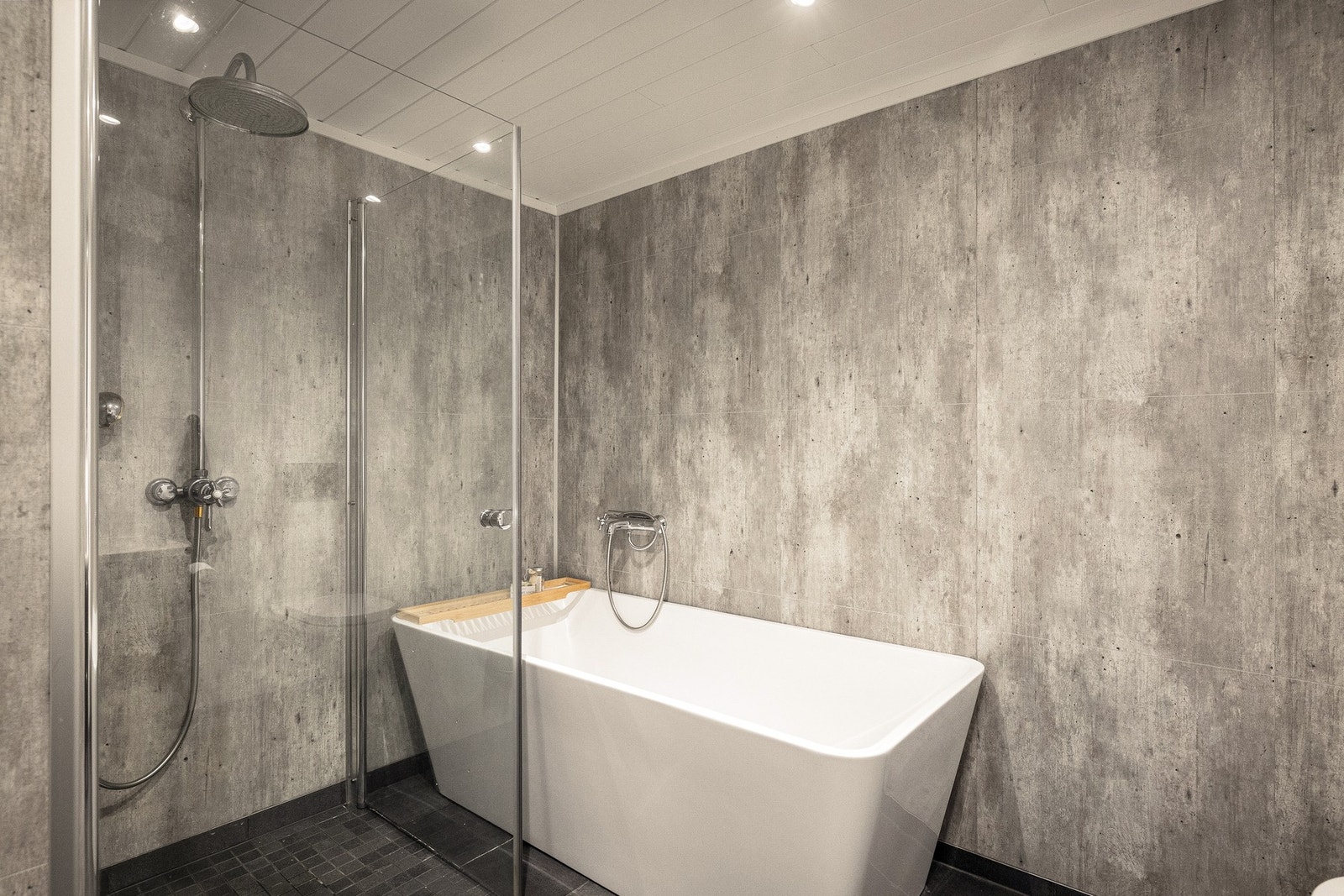 Badet er innredet med badekar med badekararmatur
tilkoblet hånddusj samt dusjhjørne. Galleribilde