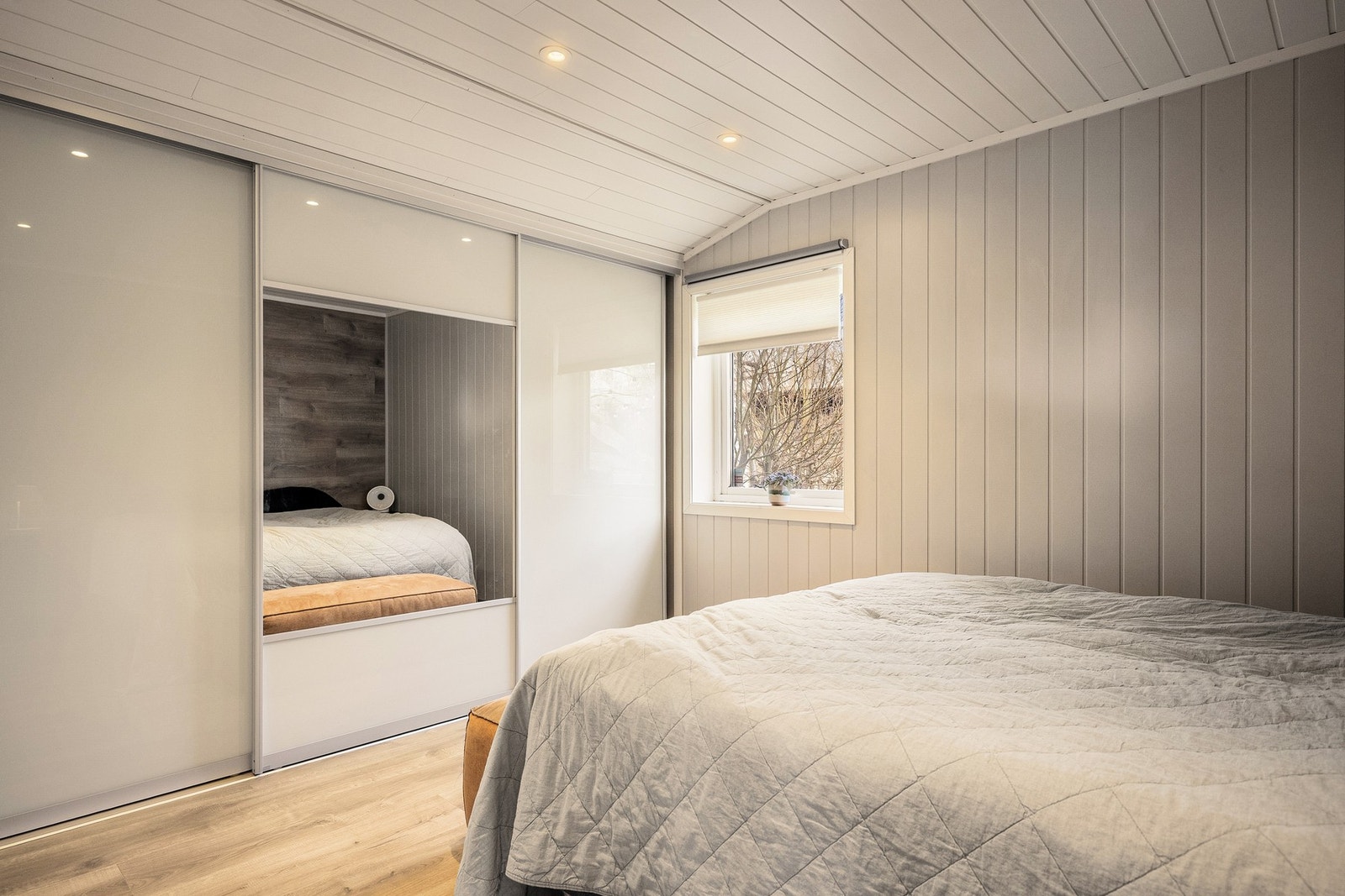 Romslig soverom utstyrt med stor skyvvedørsgarderobe. Galleribilde