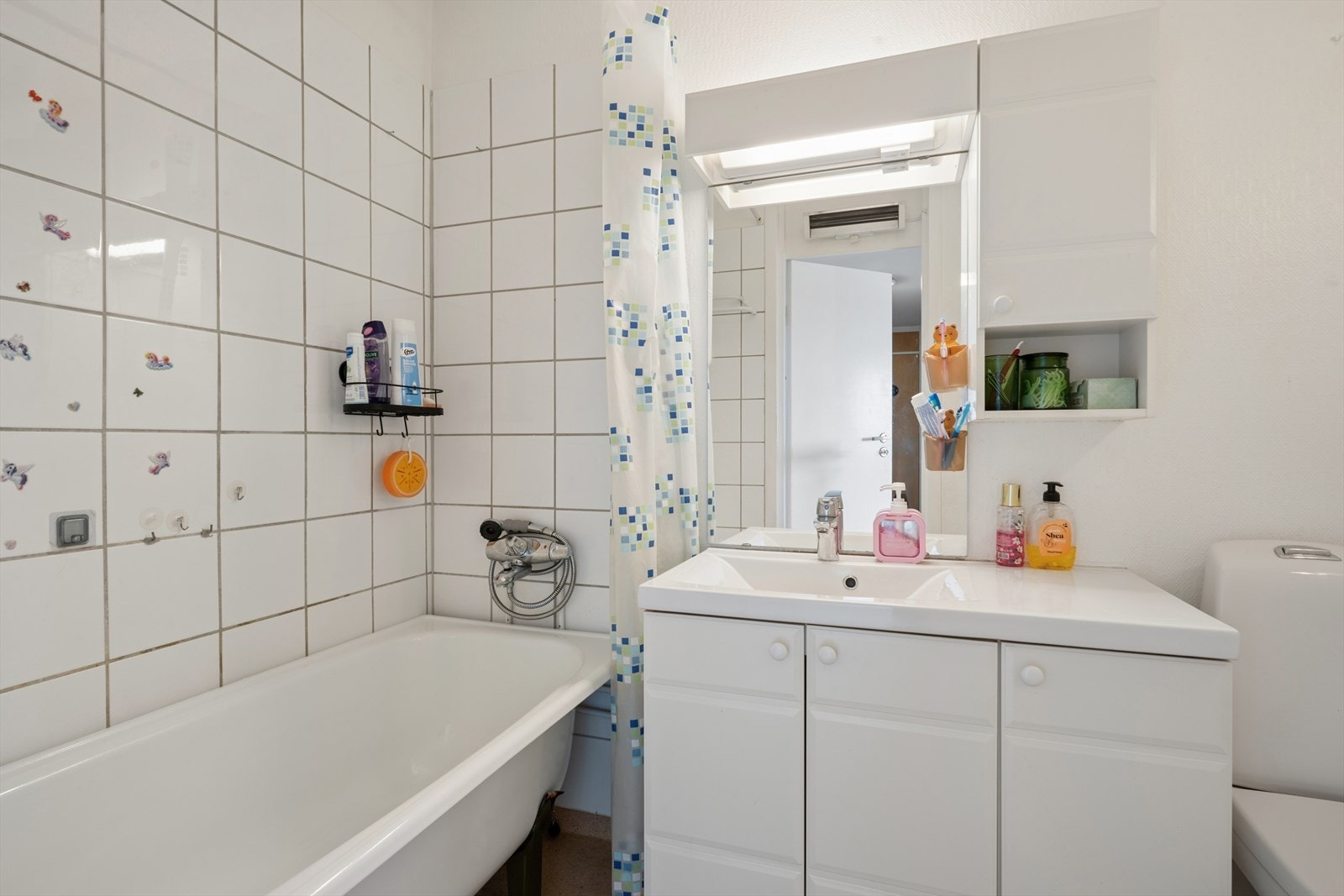 Badet er innredet med servantskap med ett-greps blandebatteri, veggspeil, gulvstående toalett, blandebatteri, dusjgarnityr og badekar. Galleribilde
