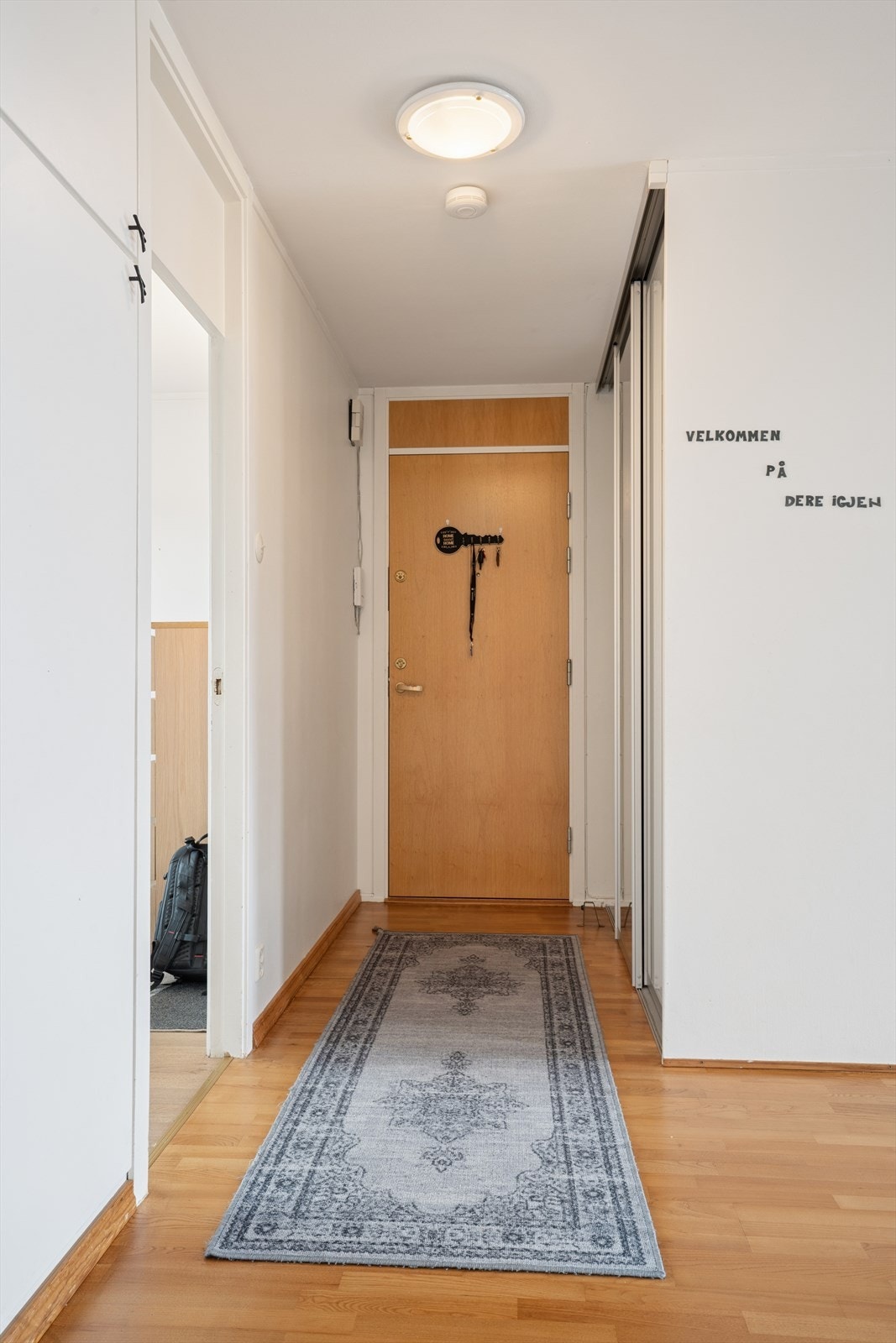 Entréen har god plass til både sko og yttertøy, med praktisk oppbevaring i en romslig skyvedørsgarderobe Galleribilde