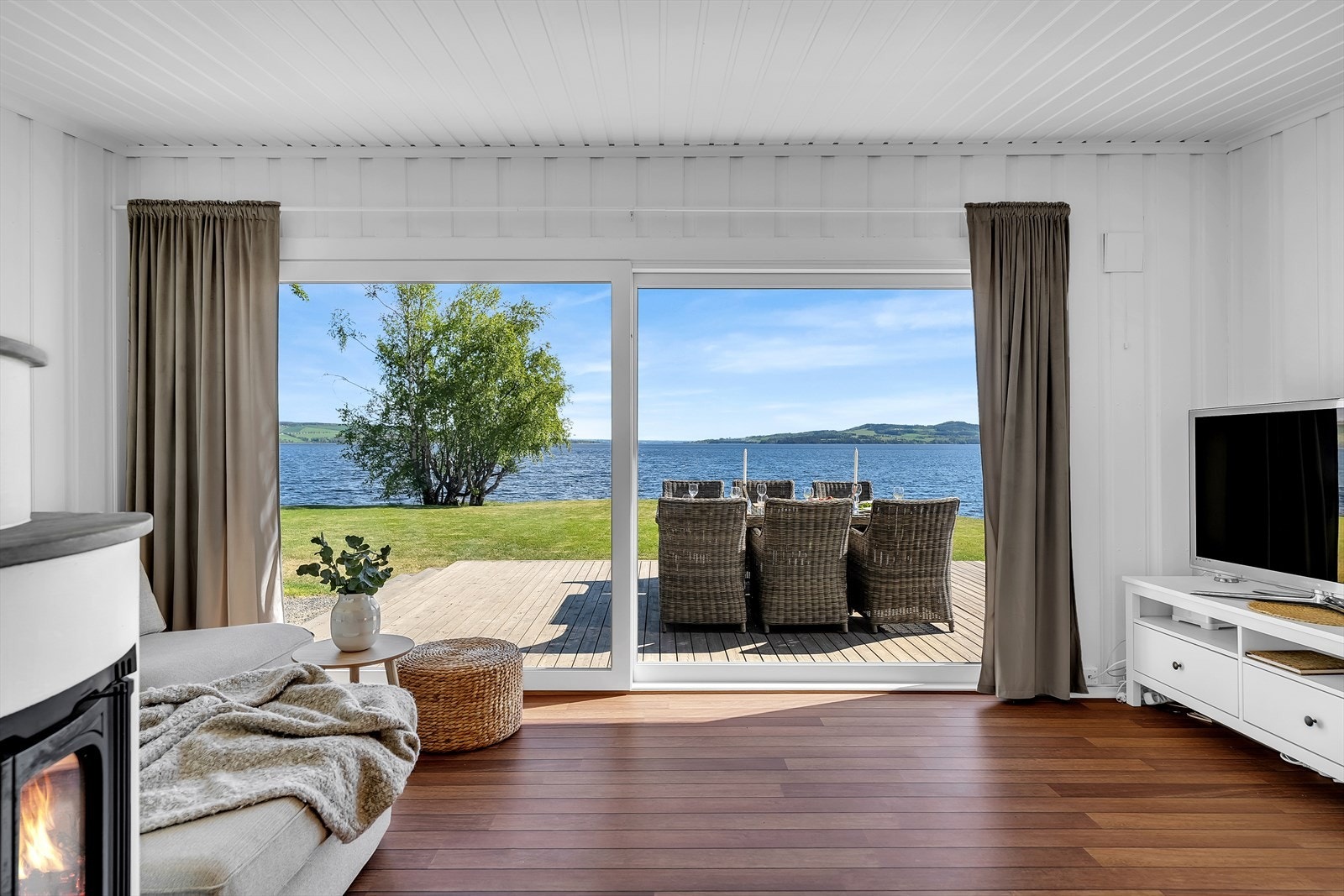 De store vindusflatene visker ut skillet mellom ute og inne og gir rommet fantastisk lys. Ny skyvedør i 2025. Galleribilde