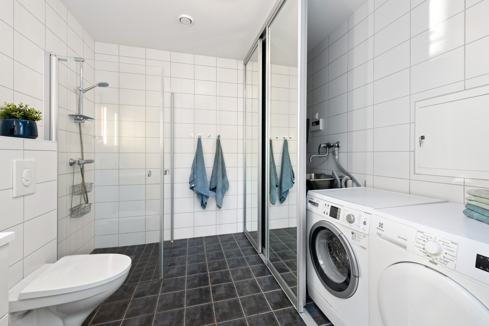 Tappekran, vaskekum og avløp for vaskemaskin er praktisk plassert i en egen nisje med skyvedører m/speilfronter. Galleribilde