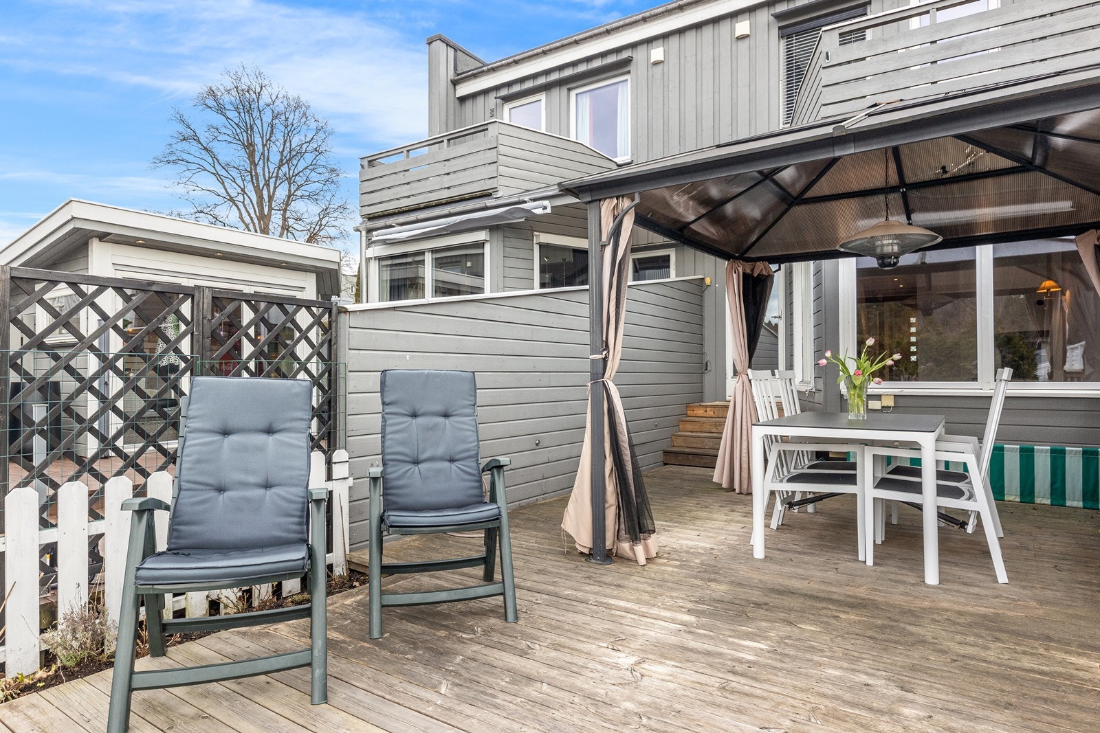 En skjermet og vestvendt terrasse som går over i en inngjerdet hage. Galleribilde