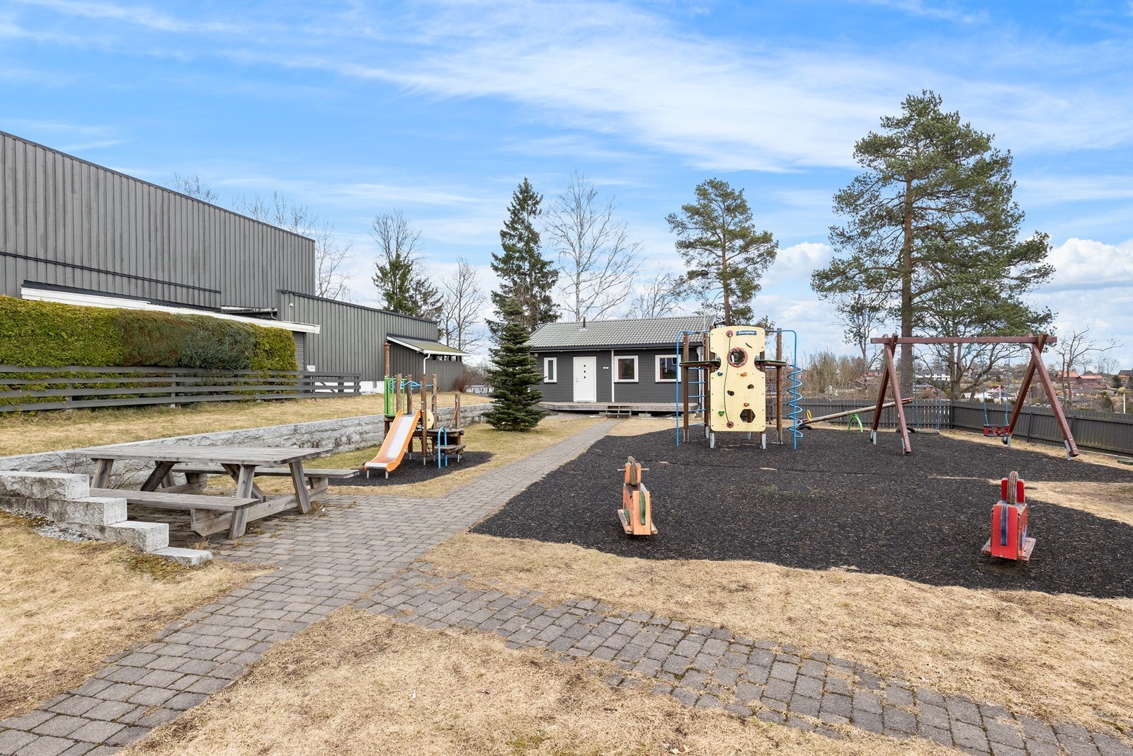 Koselig opparbeidet uteareal med lekeplass, sittegruppe og felleshus for beboernes leie/bruk. Galleribilde