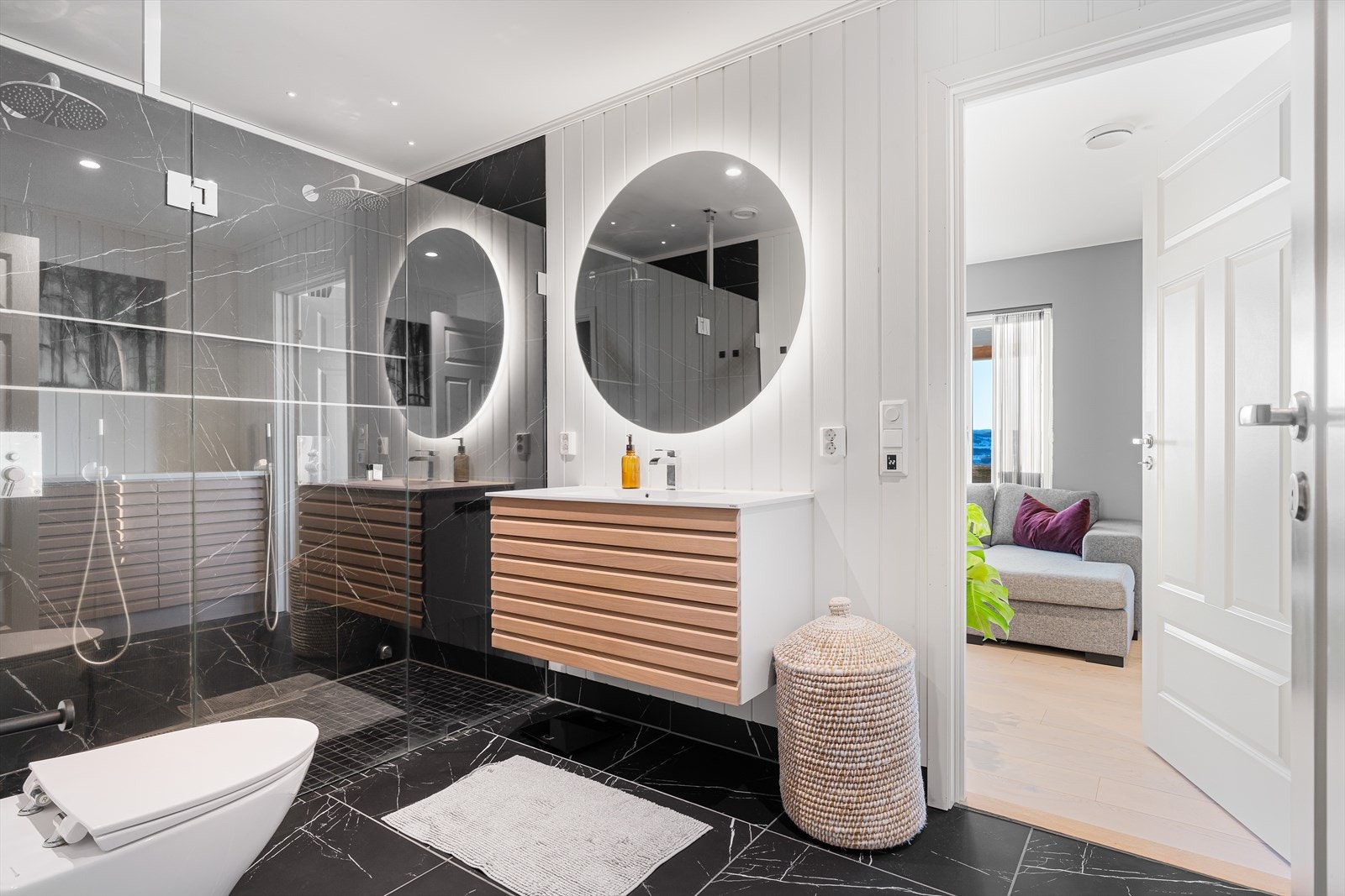 Lekkert og moderne bad med svarte marmorfliser på hovedplan. Badet er på 8 kvm og har tilgang fra stue og videre inn til soverommet i denne etasjen. Galleribilde