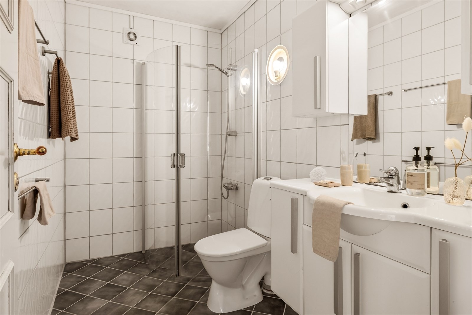 Bad 2 har fliser på gulv og vegger. Badet er innredet med servant, dusjvegger og toalett. Galleribilde
