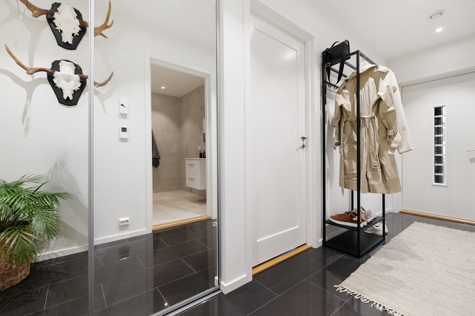 Velkommen inn! Entréen gir et ryddig og innbydende førsteinntrykk, med lyse overflater og en praktisk utforming som passer familiens hverdag. Skyvedørsgarderobe gir praktisk oppbevaringsmulighet i entréen. Galleribilde