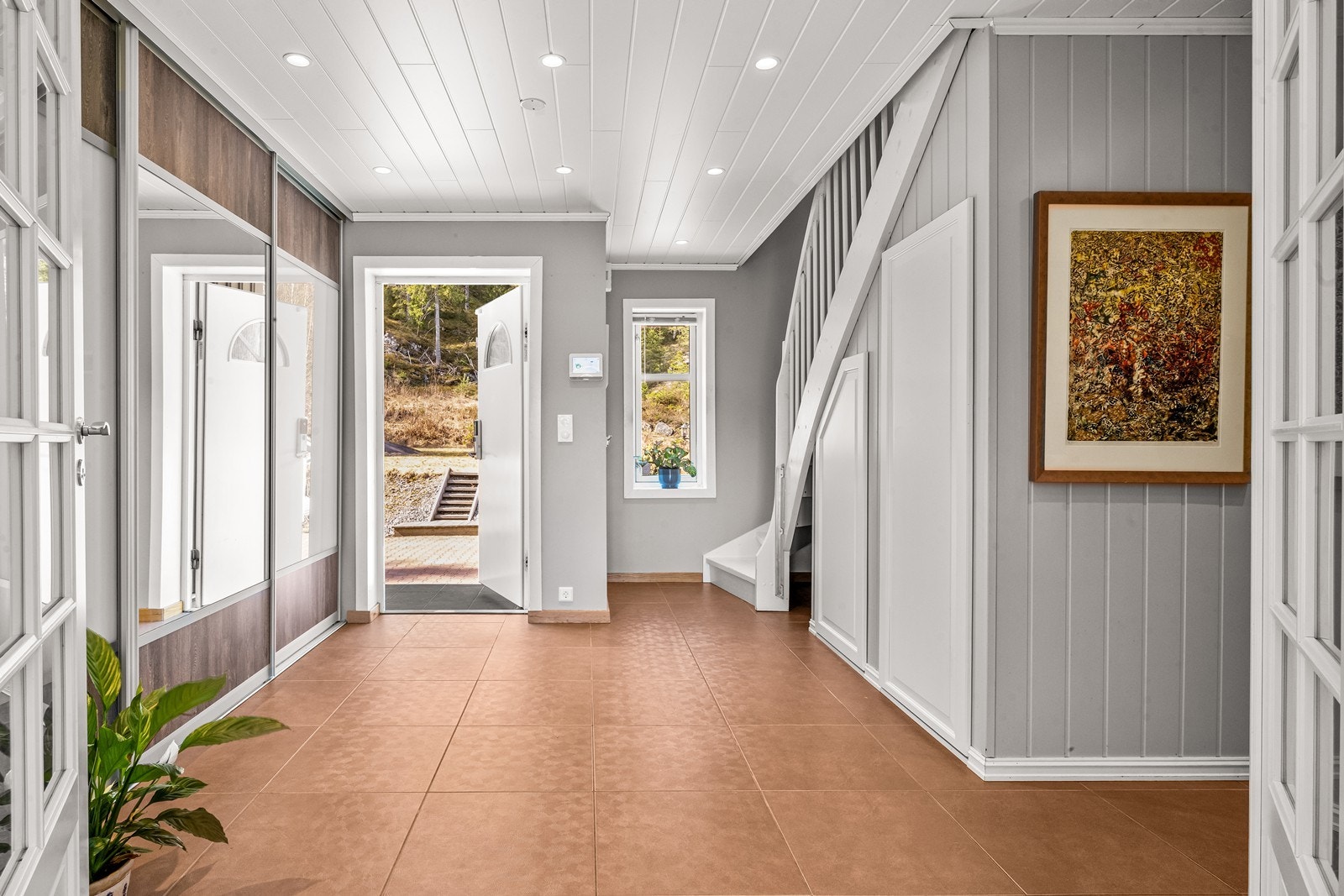 Hallen er innbydende med flislagt gulv og stor skyvedørsgarderobe. Galleribilde