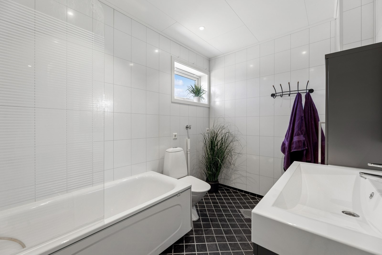 Badet er utstyrt med badekar, servantinnredning med høyskap og toalett. Galleribilde