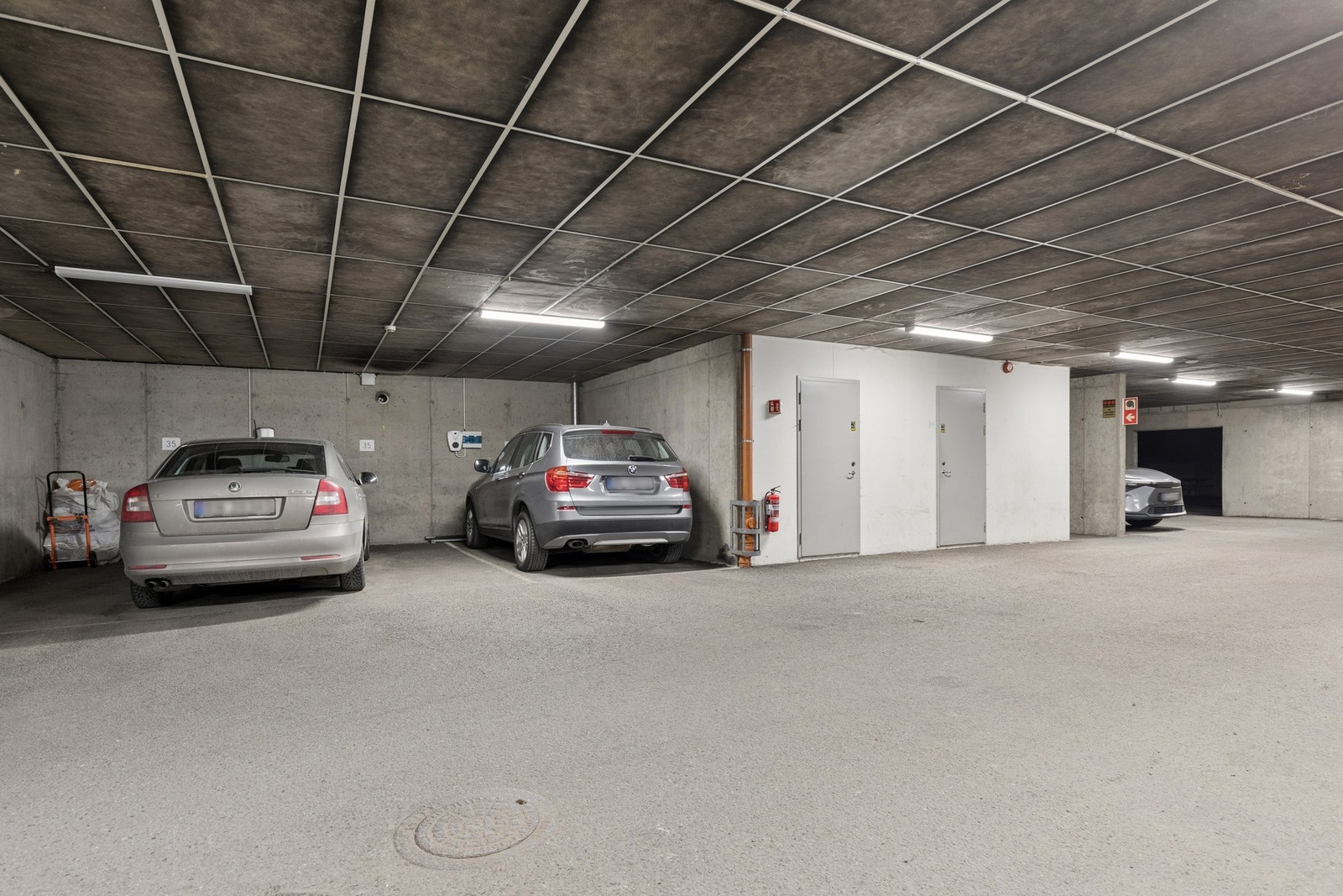 Parkeringsplass med elbillader i felles garasjeanlegg. Galleribilde