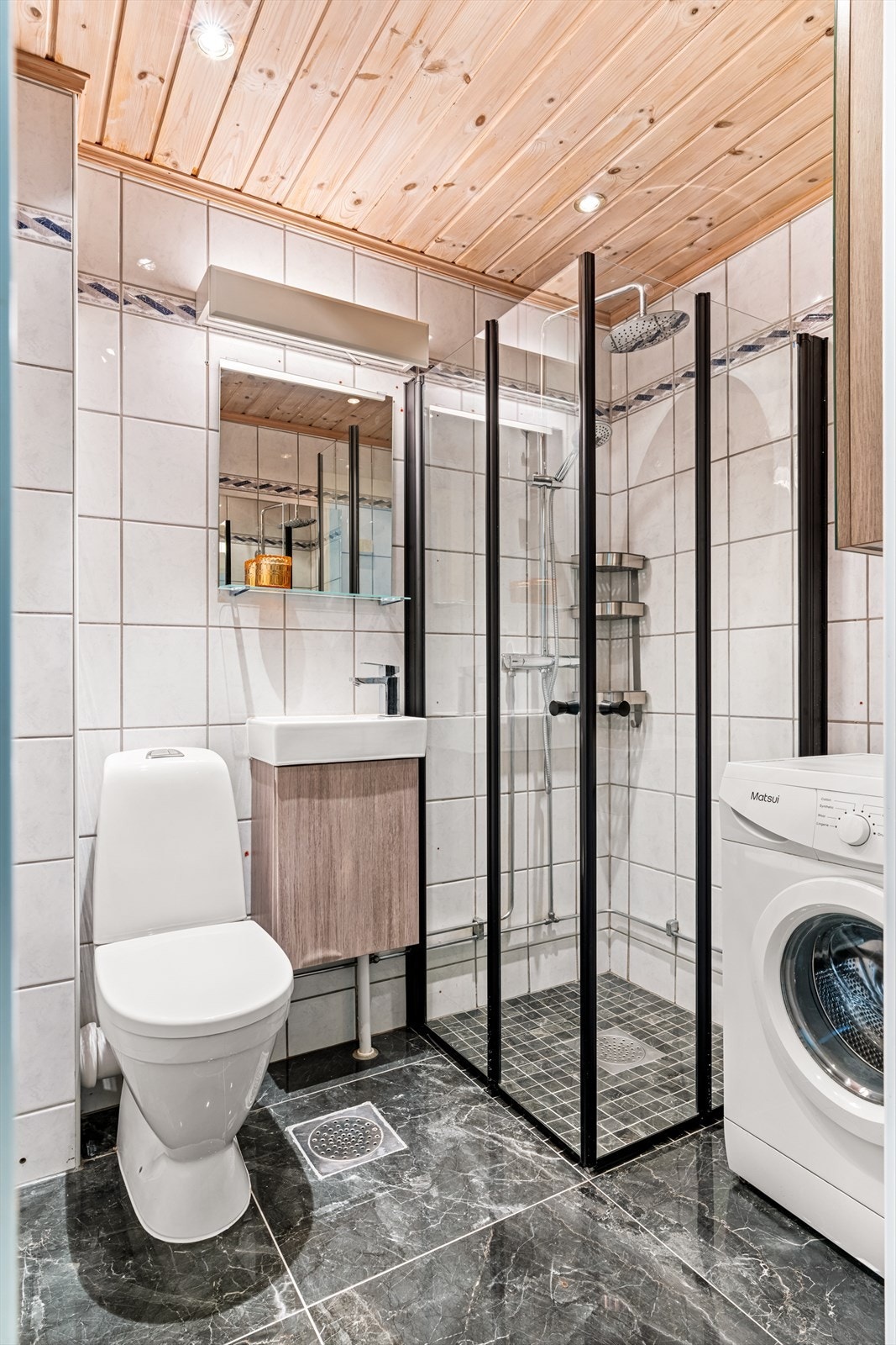 Badet har flislagt gulv med varmekabler og opplegg for vaskemaskin. Gulvflisene ble lagt i 2022. Galleribilde