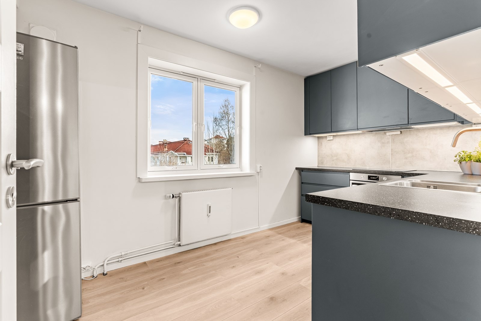 Kjøkkeninnredning fra IKEA (2021) med glatte fronter og integrert stekeovn og platetopp. Galleribilde