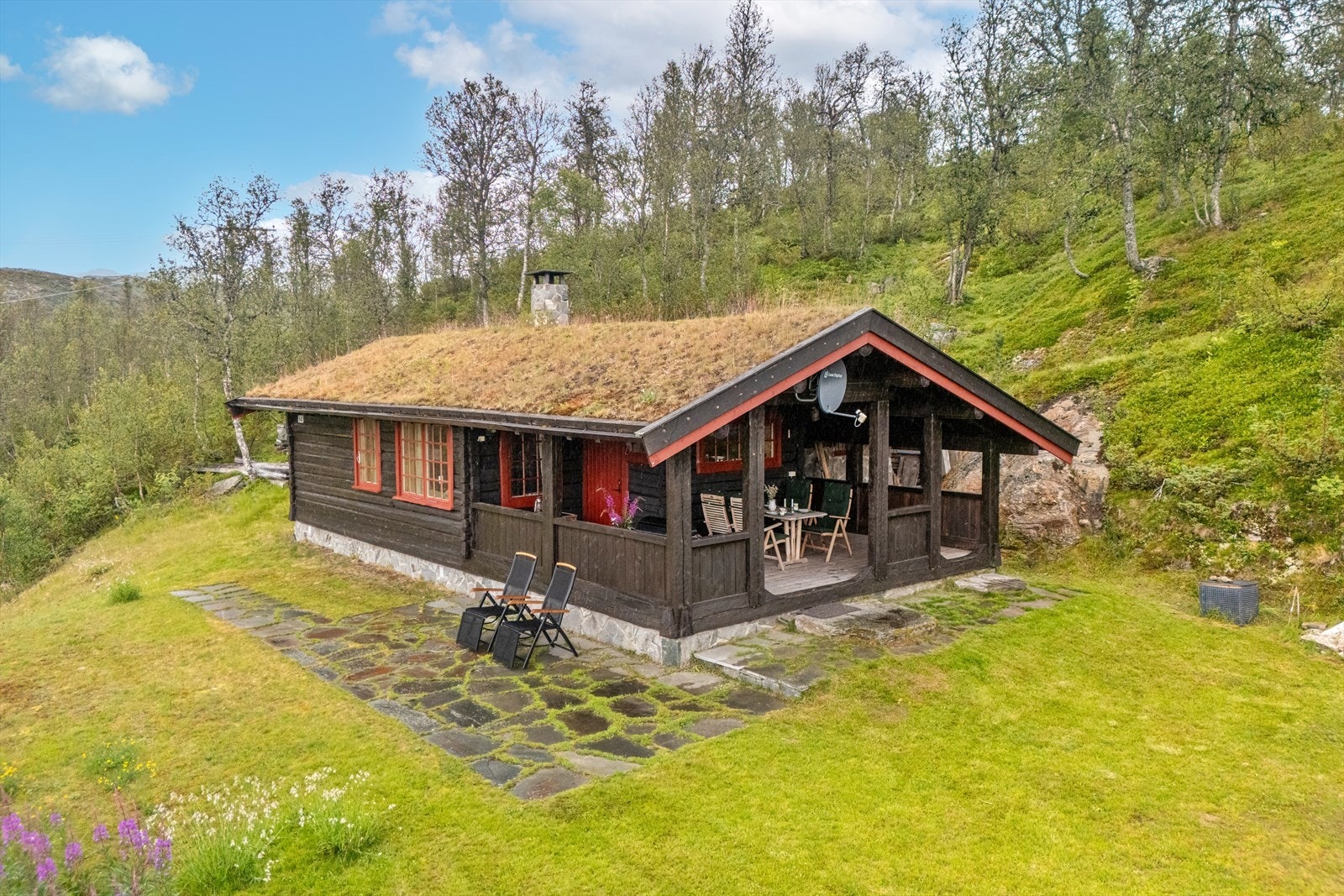 Fasade - Hellelagt platting i front av hytten. Galleribilde