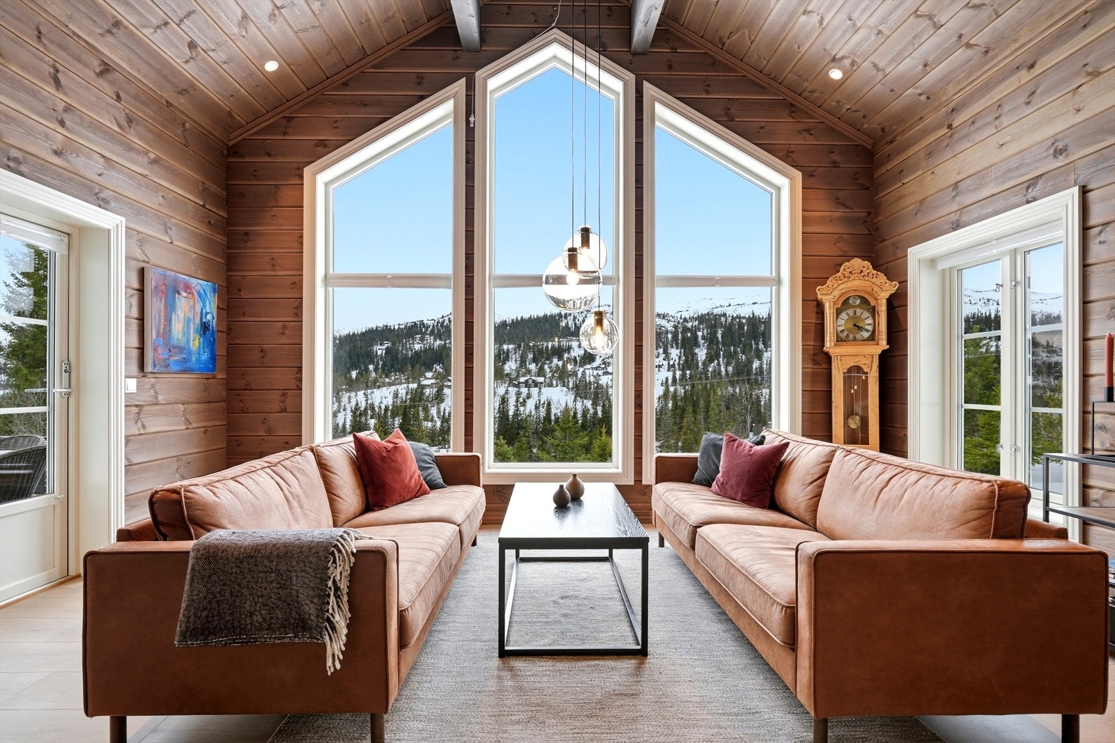 De store vindusflatene i stuen slipper naturen inn og gir en fantastisk utsikt mot fjellene. Galleribilde