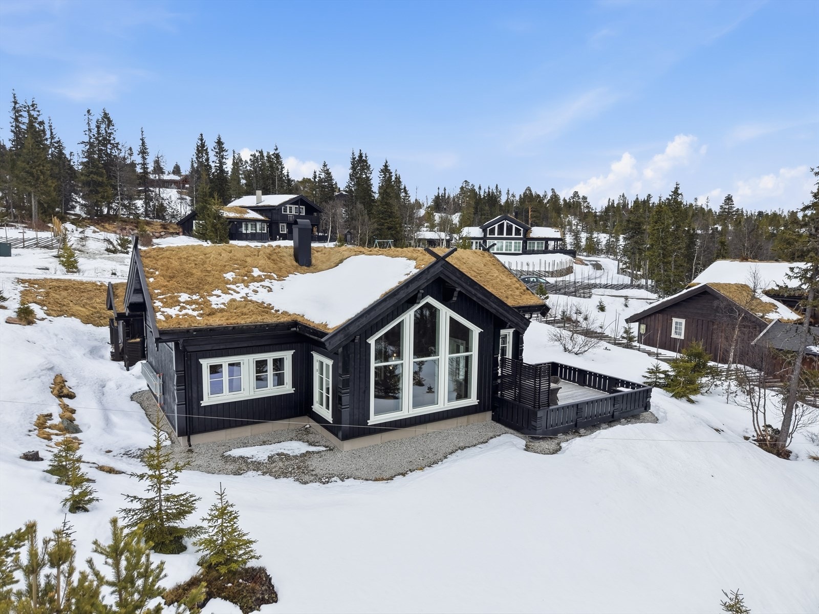 Hytta har en gjennomført stil med stående og liggende kledning, som glir godt inn i fjellandskapet. Galleribilde