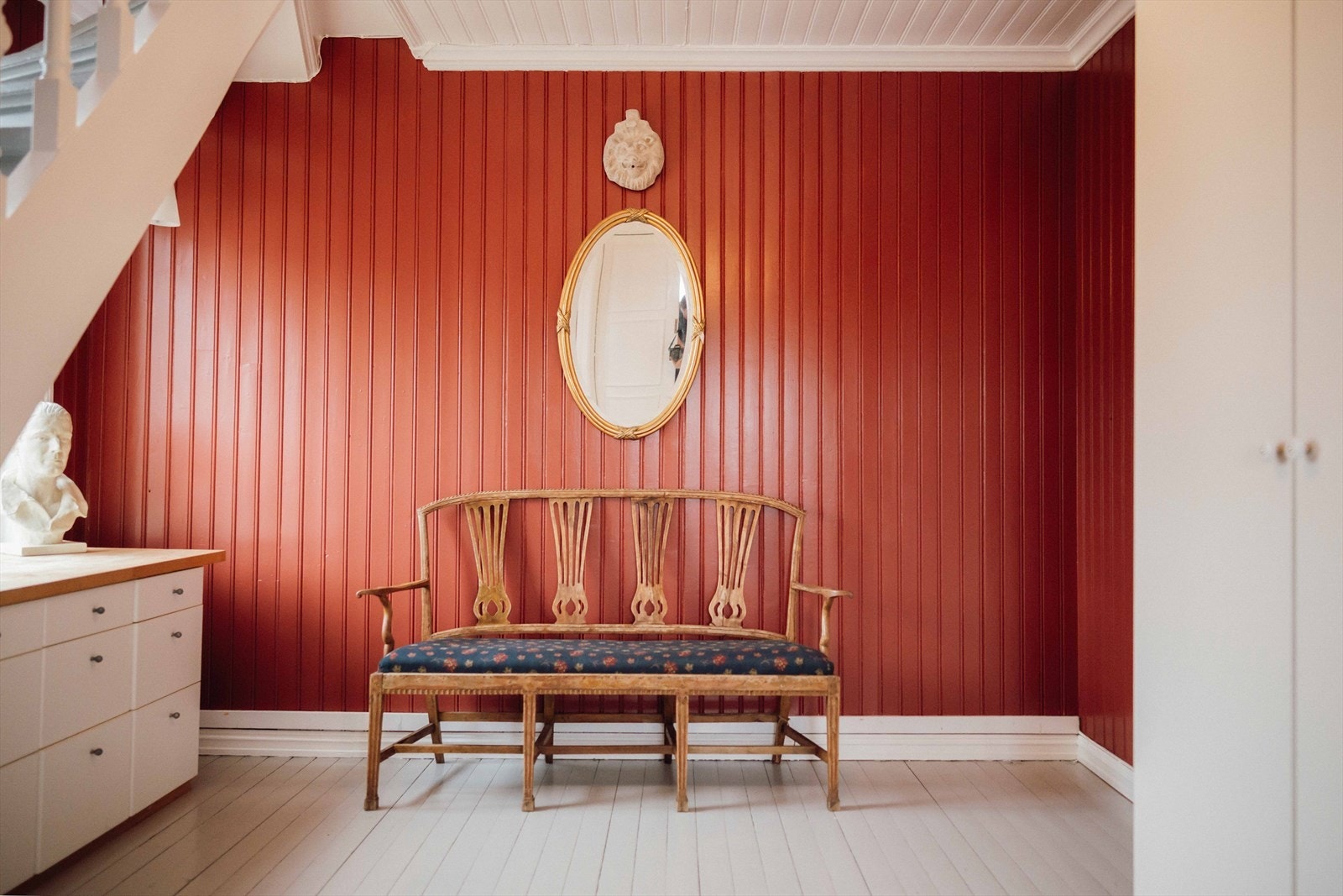 Entreen har gråmalt tregulv, rødmalte vegger og hvit himling med downlights. Langs den ene veggen er det to doble garderobeskap. Galleribilde
