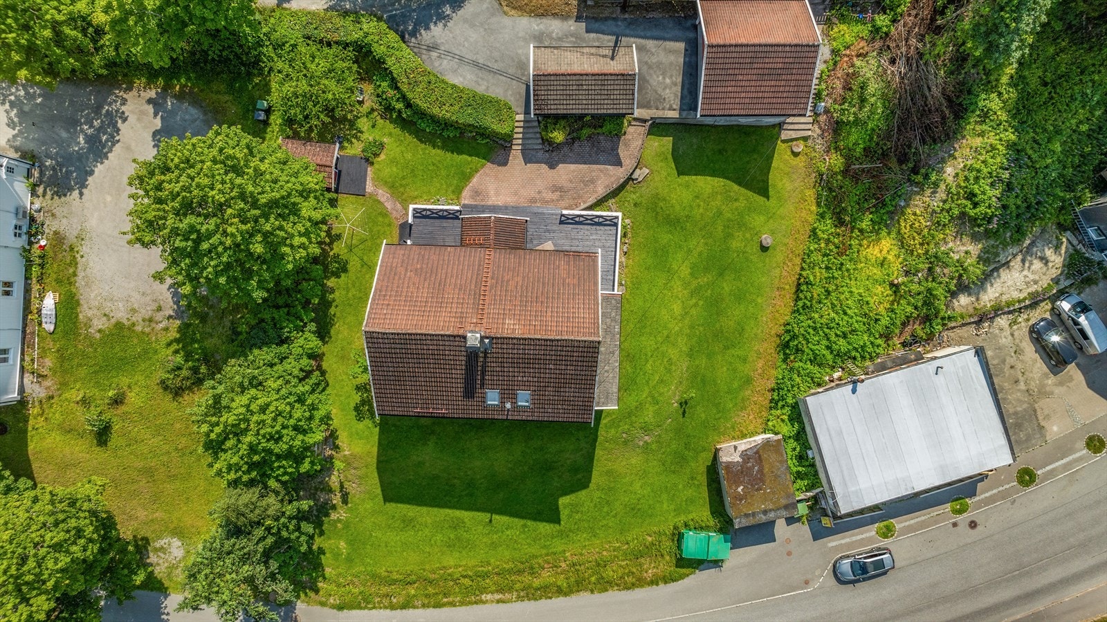 Tomten er på hele 1,3 mål og byr på romslige utearealer med en fin balanse mellom åpne gressflater og frodig beplantning. Galleribilde