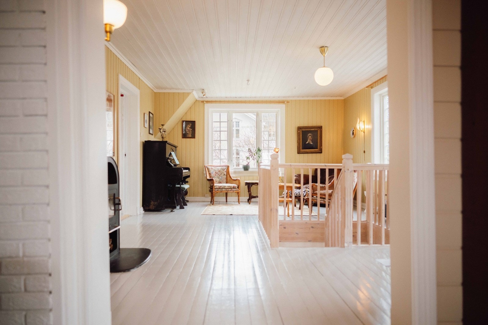 Videre har rommene gråmalt tregulv, gule vegger og noe, hvitmalt teglstein. Galleribilde