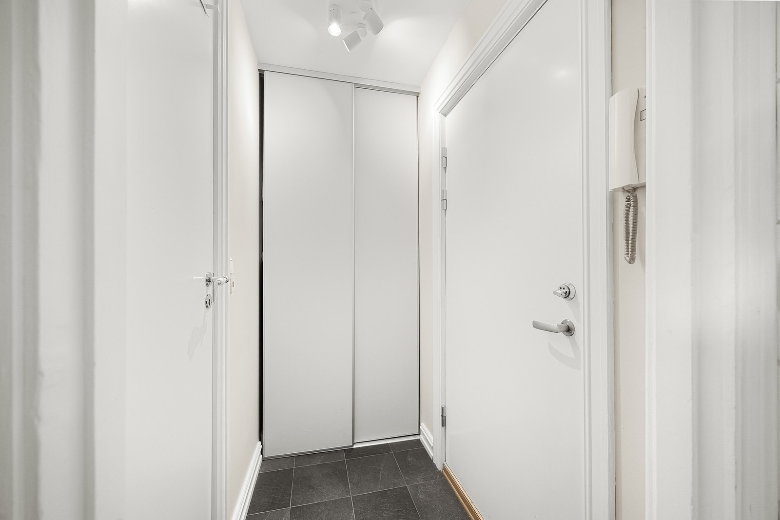 Innbydende entré som gir et godt førsteinntrykk av boligen. her er det rikelig med oppbevaring i skyvedørsgarderobe. Callinganlegg med porttelefon er plassert ved inngangsdøren. Galleribilde