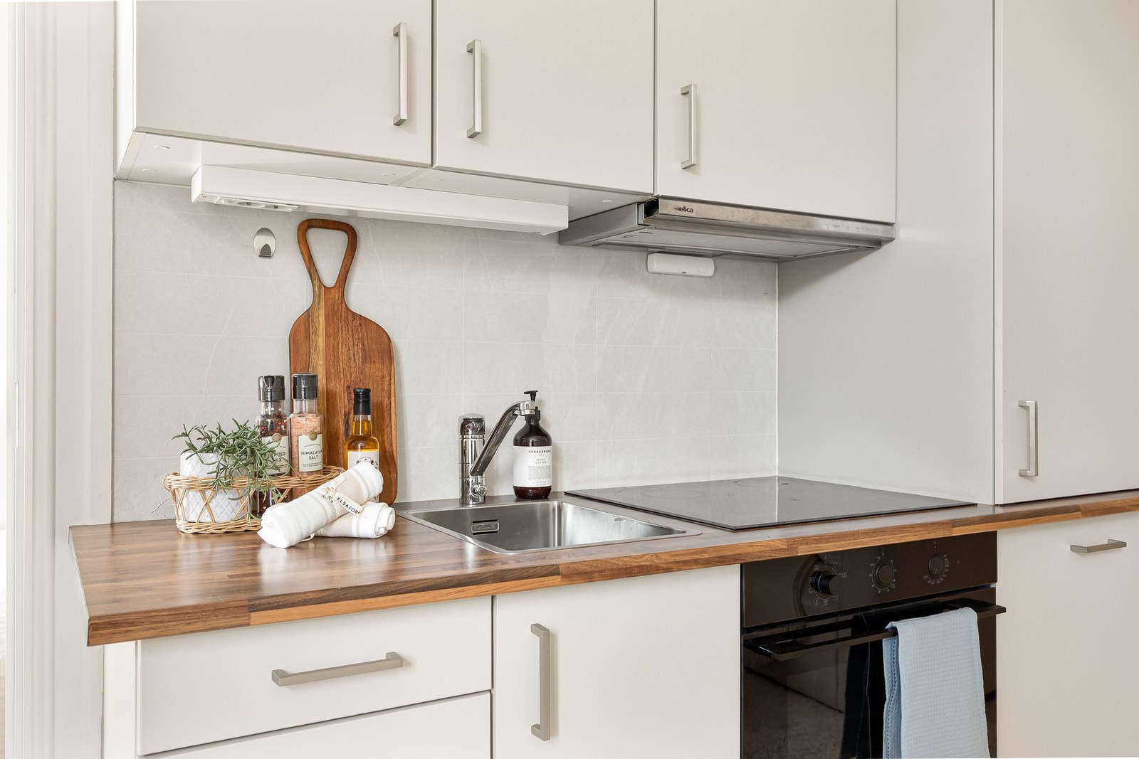 Laminat benkeplate med nedfelt stålkum og ettgreps armatur i krom. Kjøkkenet er utstyrt med integrerte hvitevarer fra Whirlpool, herunder oppvaskmaskin, kjøleskap, stekeovn og platetopp, samt avtrekksvifte fra Elica. Galleribilde