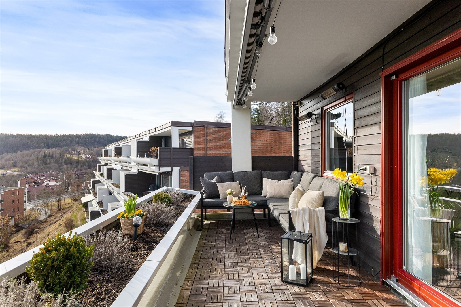 Stor balkong med god plass ulike sittegrupper, planter og grill. Galleribilde