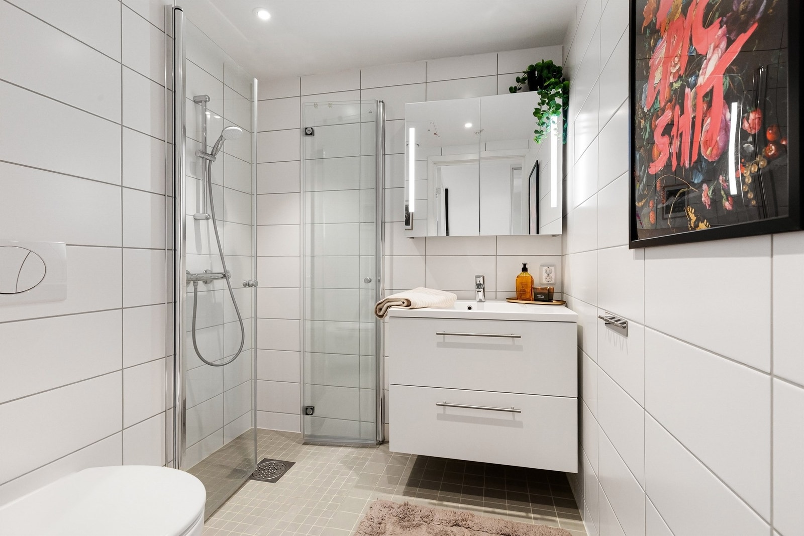 Det andre badet har adkomst fra entréen, og er utstyrt med vegghengt toalett, servantinnredning og dusjhjørne med glassdører. Galleribilde