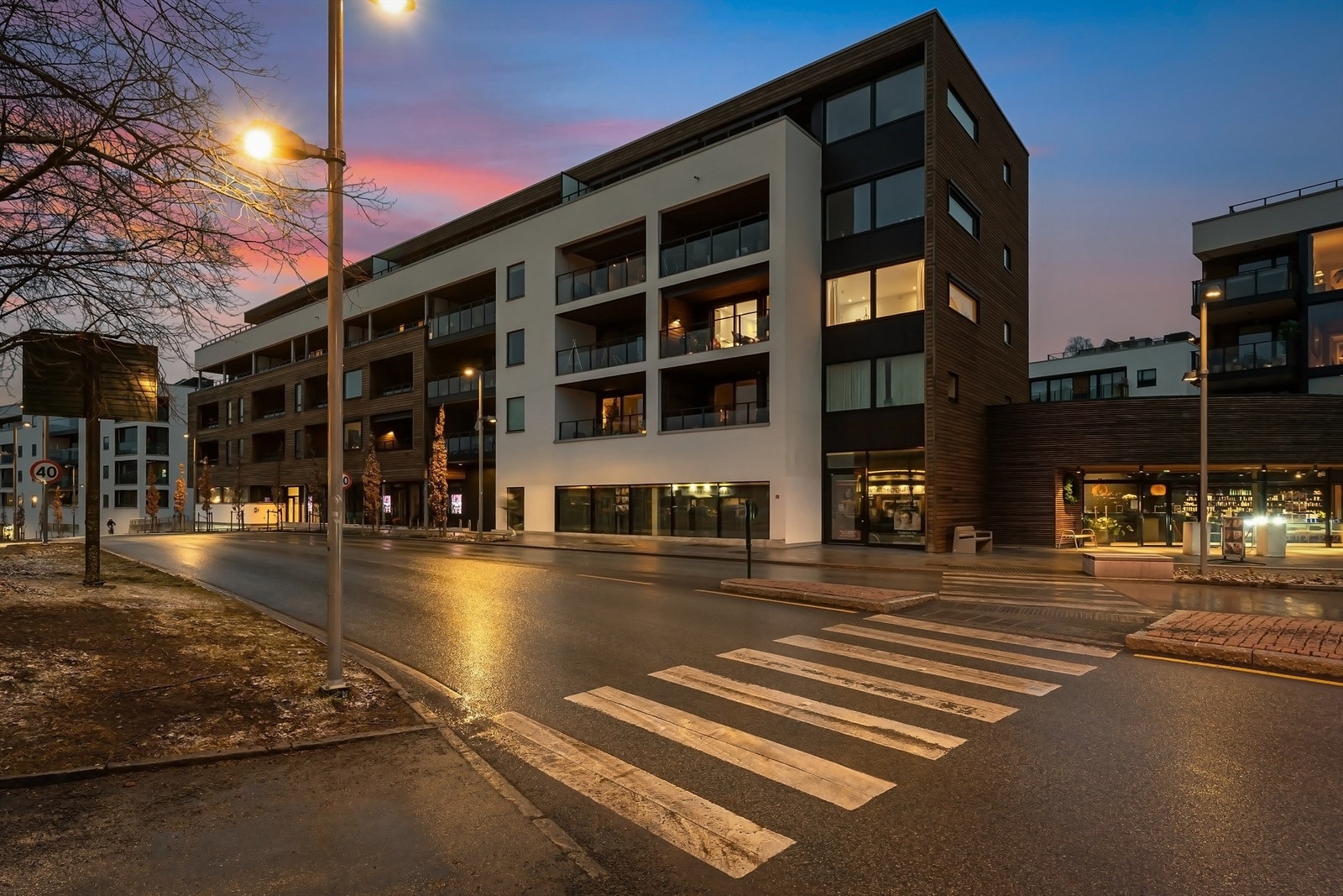 Bygget fra 2022 har en moderne fasade med en kombinasjon av trekledning og pussede fasadeplater. Galleribilde