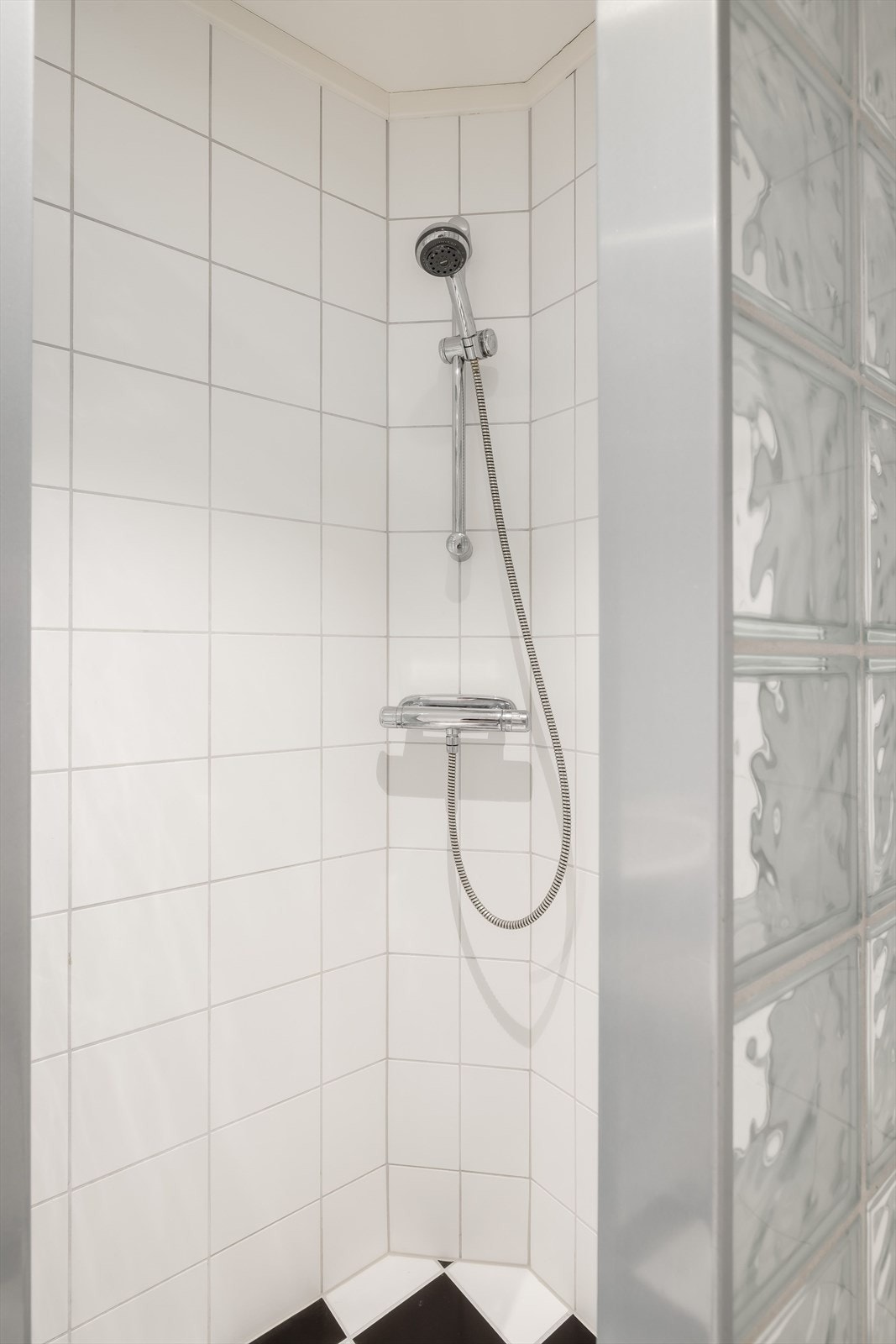 Dusjnisje med glassbyggerstein og veggmontert dusjbatteri. Galleribilde