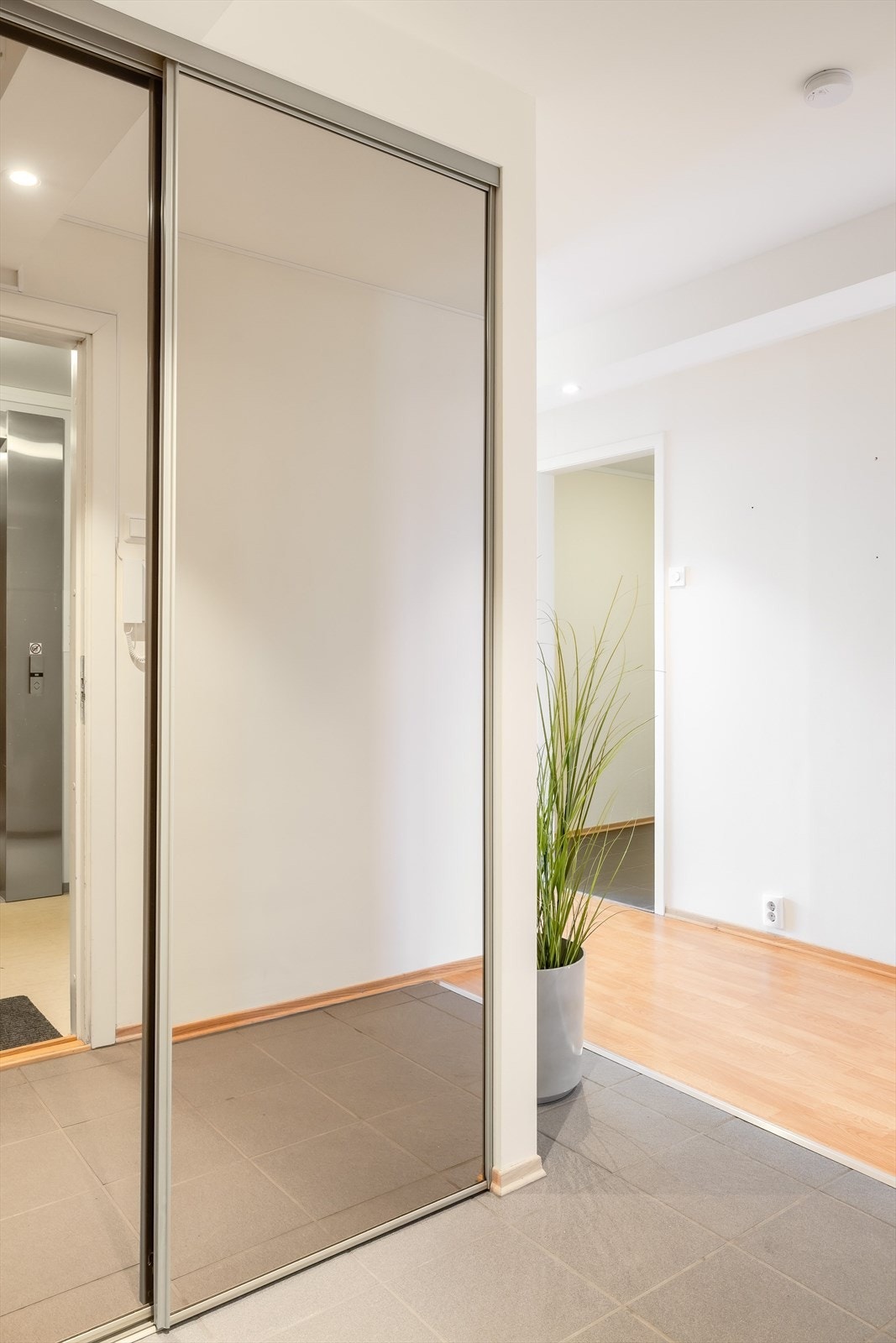 Entré med flislagt gulv og skyvedørsgarderobe. Galleribilde