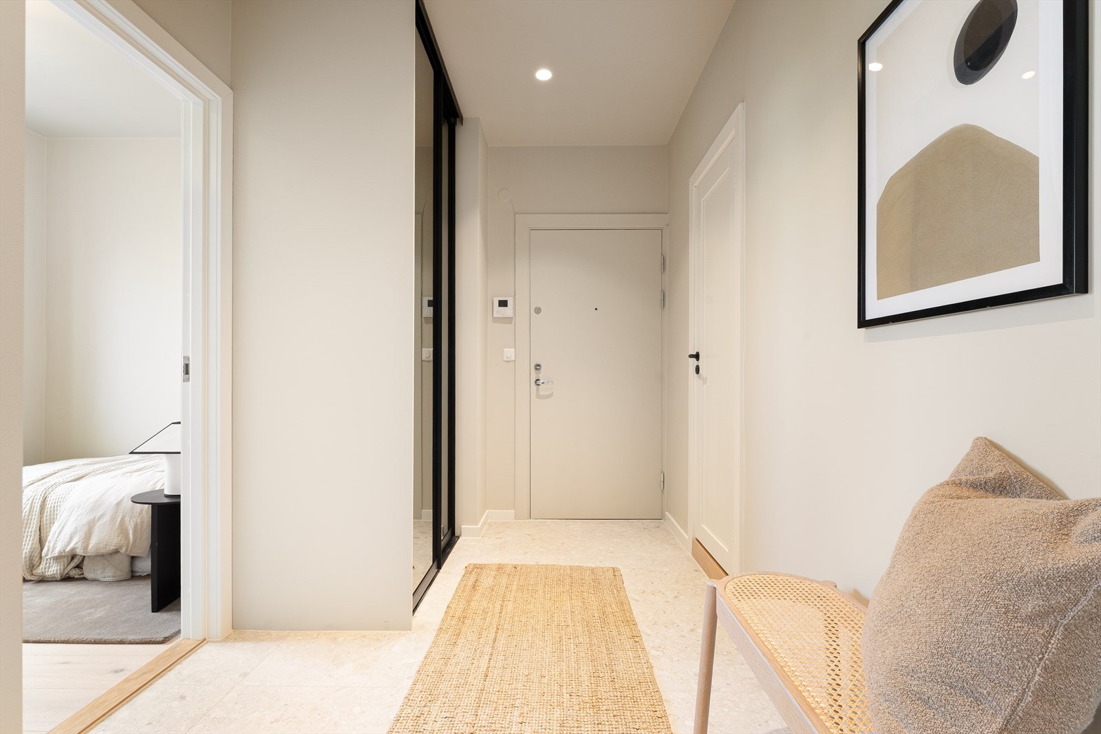 Gang/entré med takhøy skyvedørsgarderobe. Det er fliser på gulv og downlights i himling Galleribilde