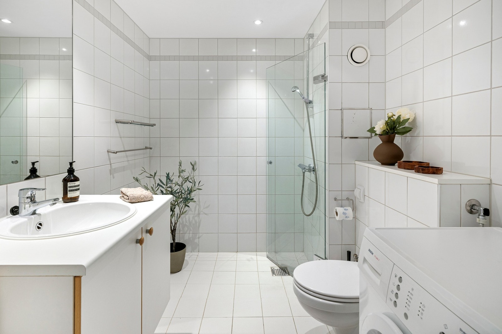 Baderommet er helhvitt - en nøytral stil som enkelt kan krydres med farger på håndklær, badematter og annet tilbehør. Galleribilde