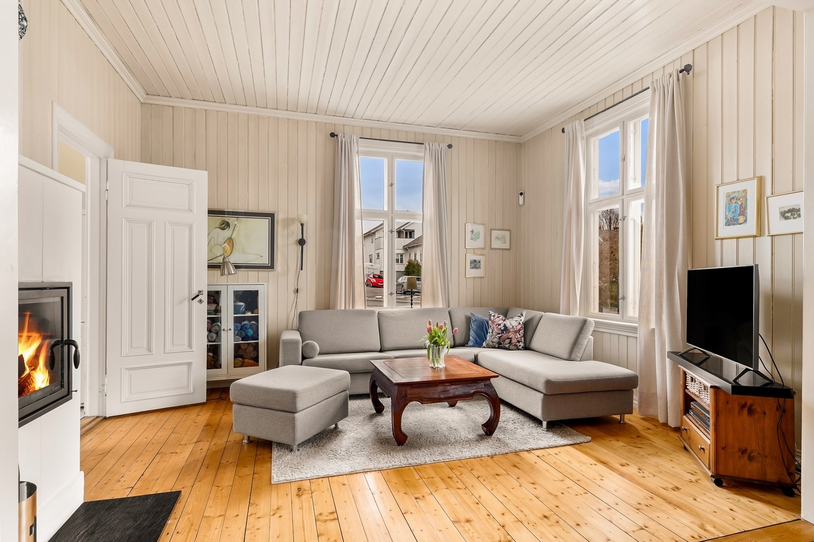 Én av boligens 3 stuer med tregulv, malt panel i tak og på veggene. Galleribilde