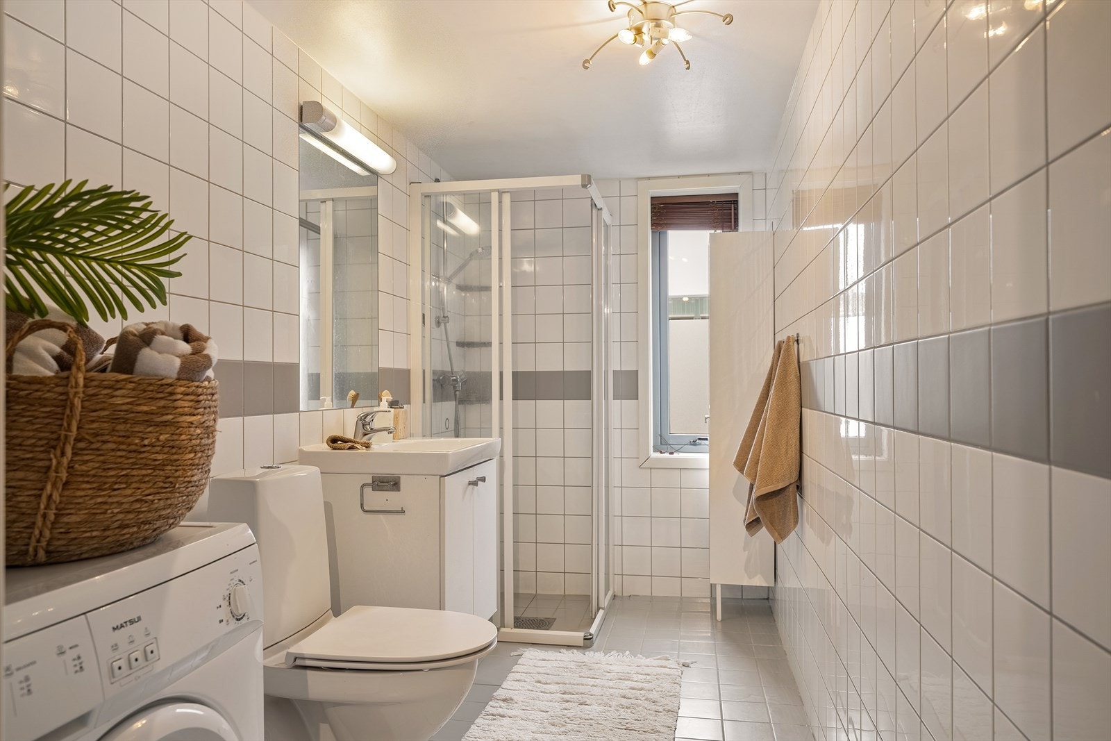 Badet er innredet med klosett, dusjhjørne, servant med speil og underskap, samt vegghengt skap. Galleribilde