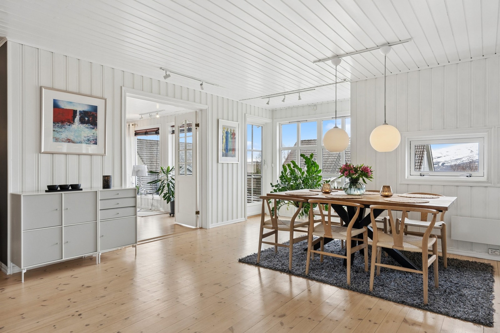 Innbydende spisestue med store vindusflater som slipper inn rikelig med naturlig lys og skaper en lys og luftig atmosfære. Galleribilde