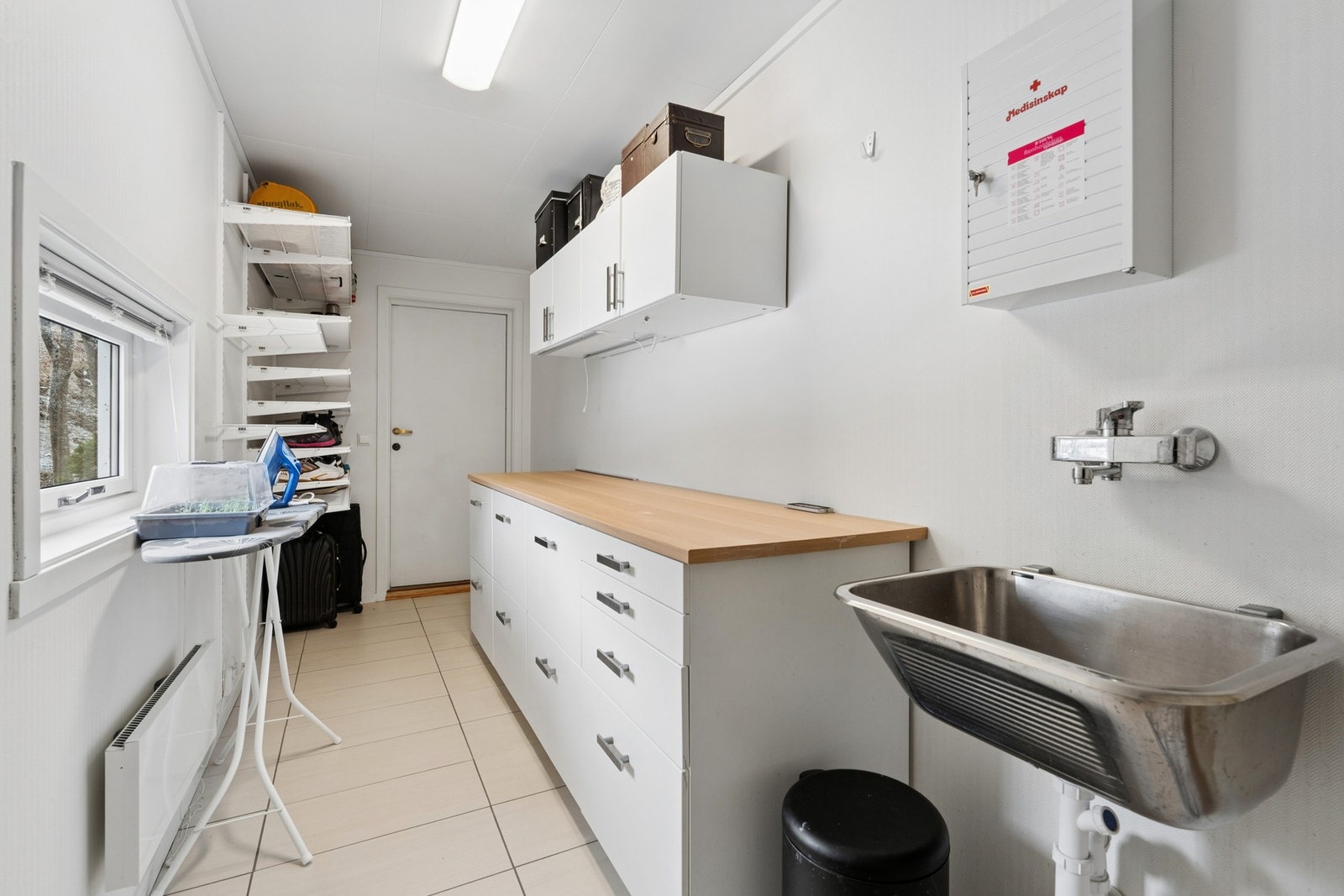 Praktisk og funksjonelt vaskerom med gode arbeidsflater og opplegg for vaskemaskin og tørketrommel. Galleribilde