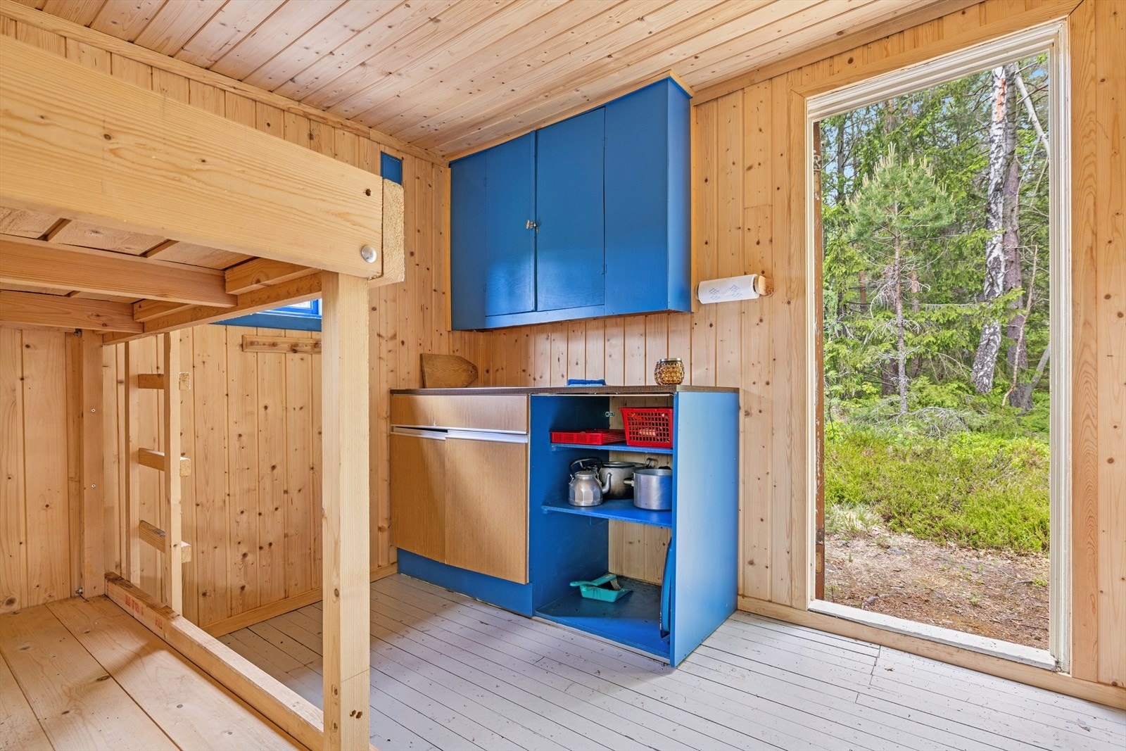 Enkel blåmalt kjøkkeninnredning med malte flater og benkplate av laminat. Galleribilde