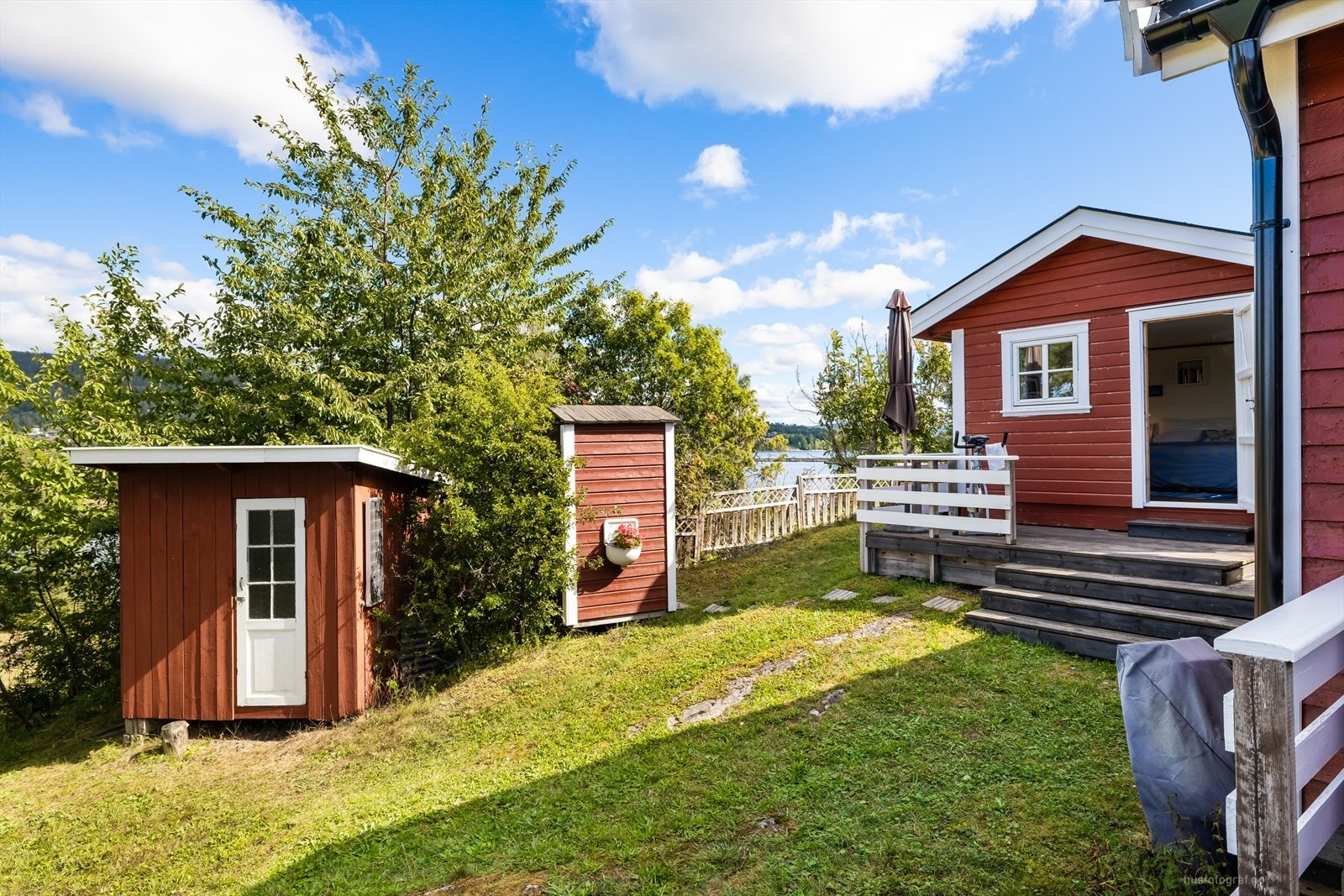 Tomten er pent opparbeidet med gressplen og beplantninger. Galleribilde