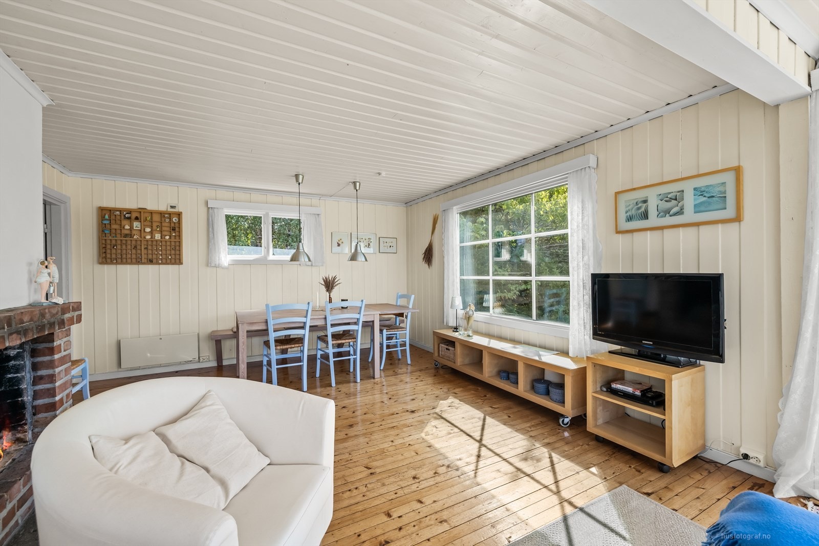 Spisestuen og stuen er pent innredet med tregulv og panel på vegg malt i en dus fargetone. Galleribilde