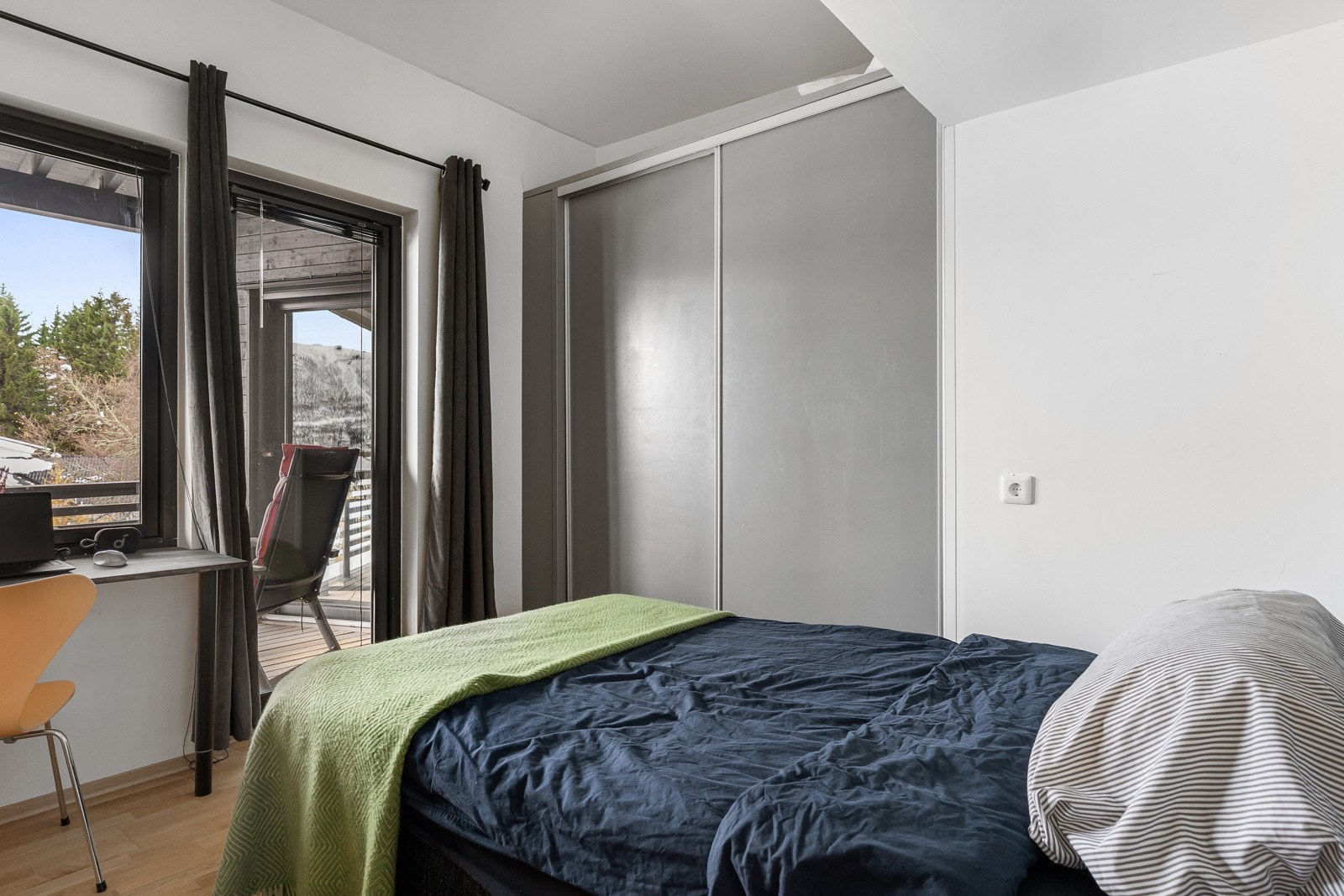Romslig soverom med garderobeskap og utgang til veranda.