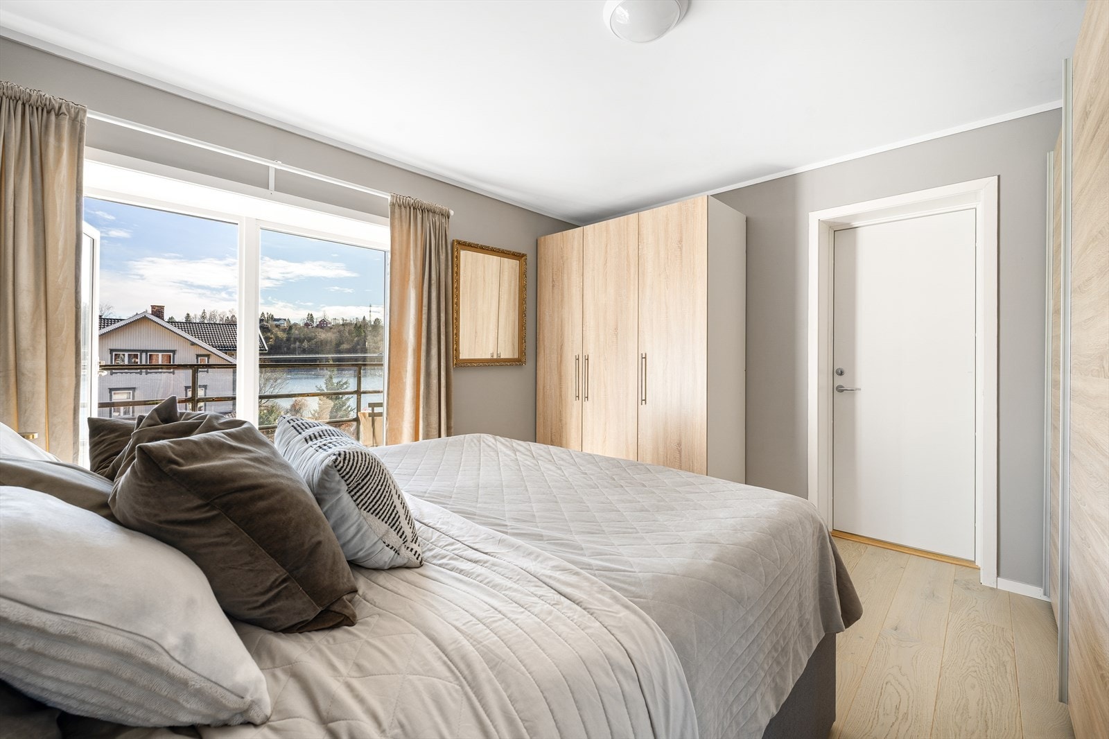 Rommet har store vinduer med utsikt mot vannet, og en garderobe med lyse trefronter gir god oppbevaringsplass. Galleribilde
