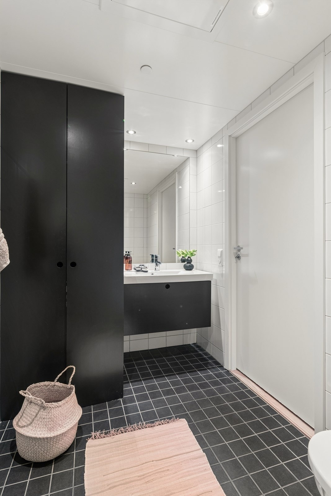 Helfliset baderom med vannbåren gulvvarme. Svært praktisk løsning med skjult opplegg for vaskemaskin bak høyskap. Galleribilde