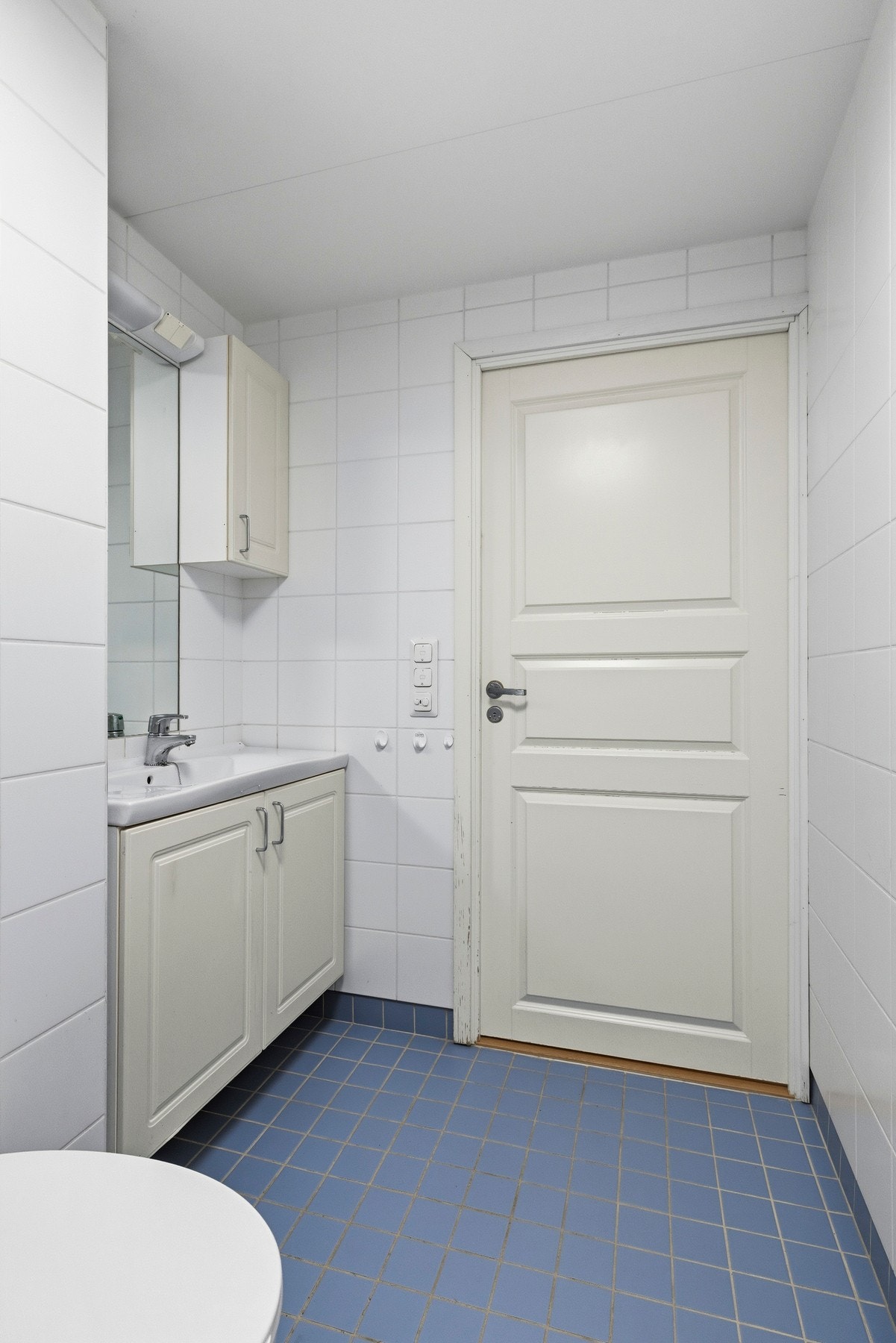 Videre har badet vegg-montert toalett , innmurt speil med overliggende belysning, baderomsinnredning med malte profilerte fronter og heldekkende servant. Galleribilde