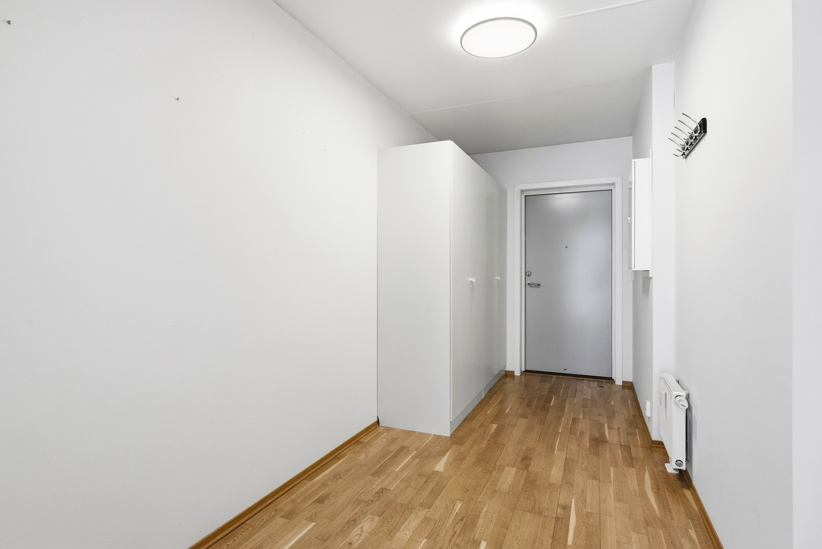 Gang. Rommet har 3-stavs eikeparkett på gulv, mens vegger og tak er malt i en lys farge, noe som er gjennomgående for resten av leiligheten. Galleribilde