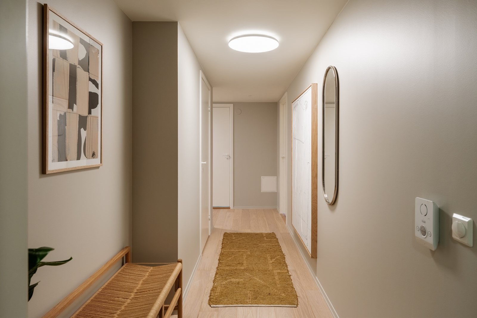 Innbydende entré med et ryddig og stilrent førsteinntrykk. Gangen har gode oppbevaringsmuligheter og plass til yttertøy og sko, samtidig som den lyse fargepaletten og de rene linjene gir en luftig følelse. Galleribilde