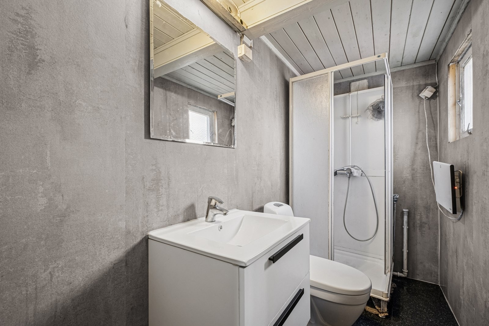 Baderommet har belegg på gulv og baderomsplater på veggene. Badet er utstyrt servant, toalett, dusjkabinett, samt opplegg for vaskemaskin. Galleribilde