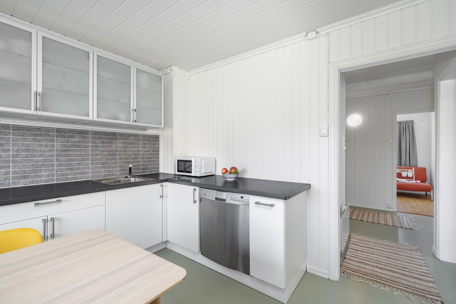 Laminert benkeplate med gode arbeidsflater med nedfelt oppvaskkum. Det er montert kjøkkenplater mellom benkeplater og overskap. Galleribilde