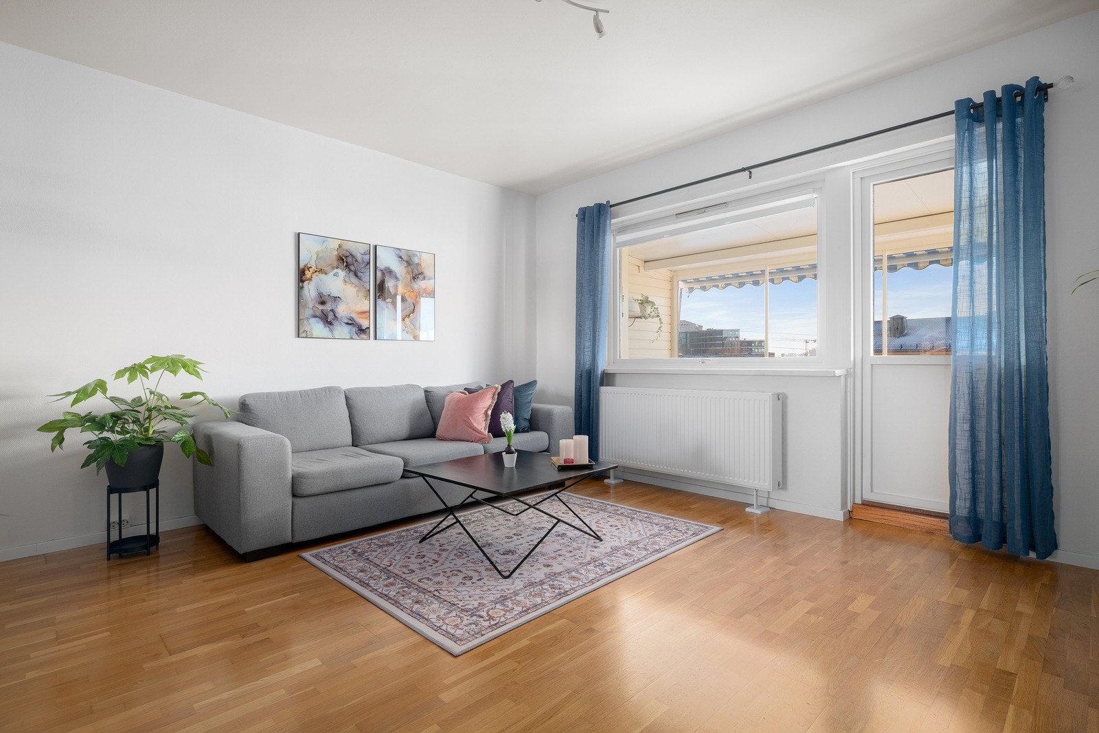 Leilighetens stue er et lyst og innbydende rom med store vindusflater. Galleribilde