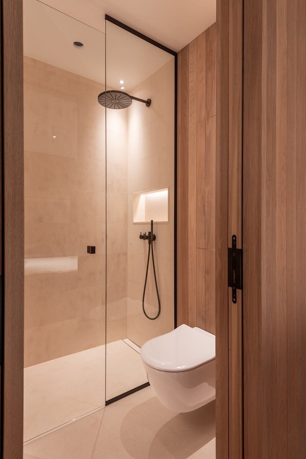 Det andre badet kombinerer fliser med trepanel, og er innredet med servant, dusj og vegghengt toalett. Galleribilde