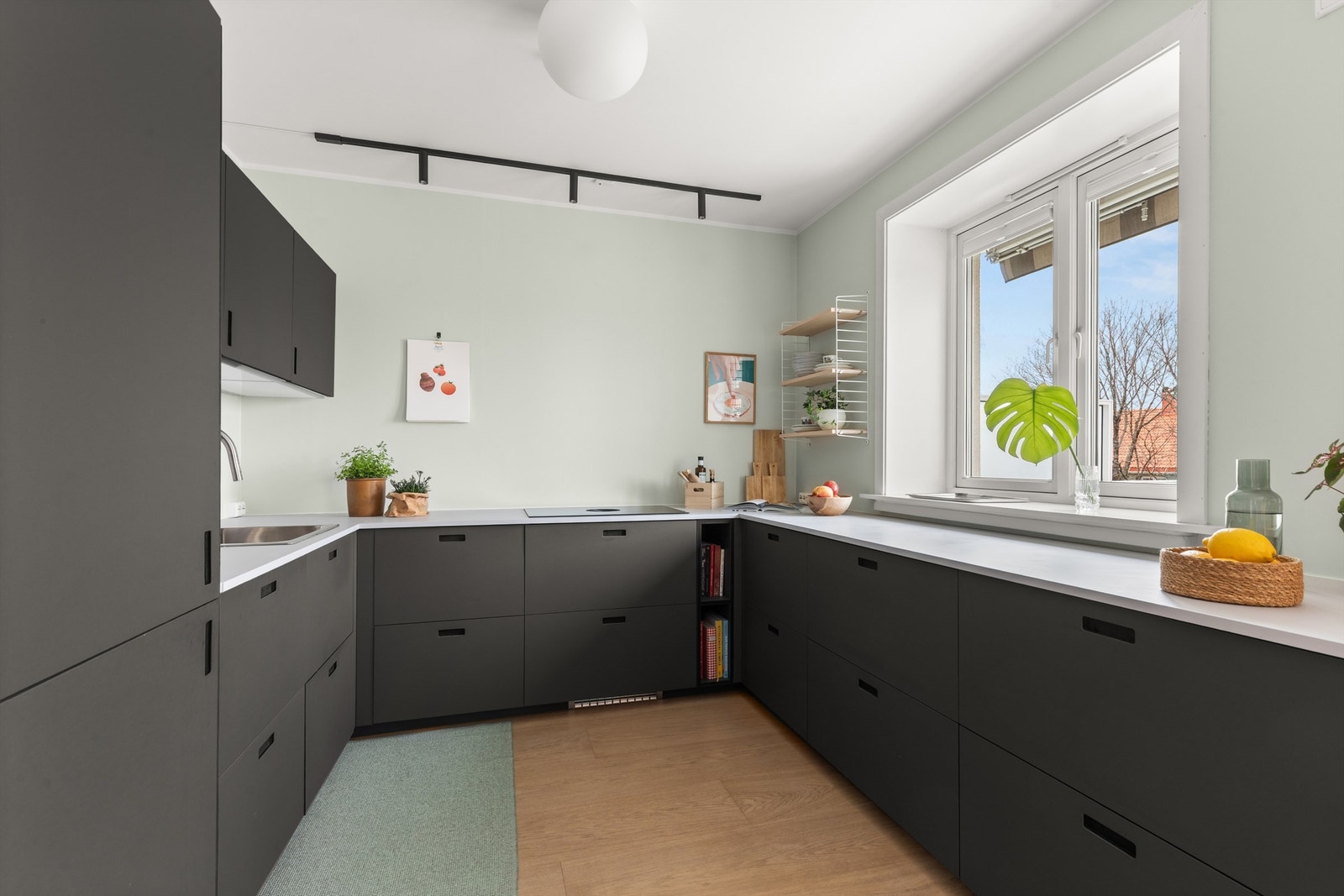 Kjøkkenet ble pusset opp i 2021 og har moderne innredning med glatte linoleumsfronter og laminat benkeplate med nedfelt vaskekum. Galleribilde