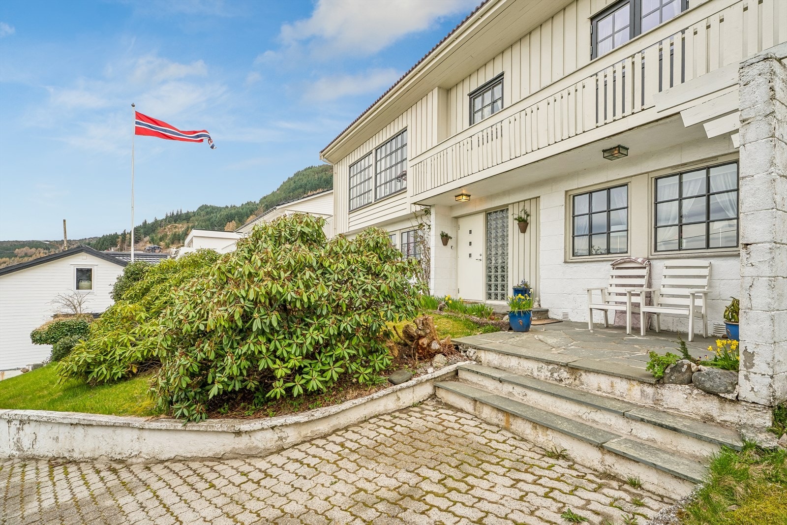 Hovudinngangen med ein flislagt platting ved inngangspartiet. Galleribilde